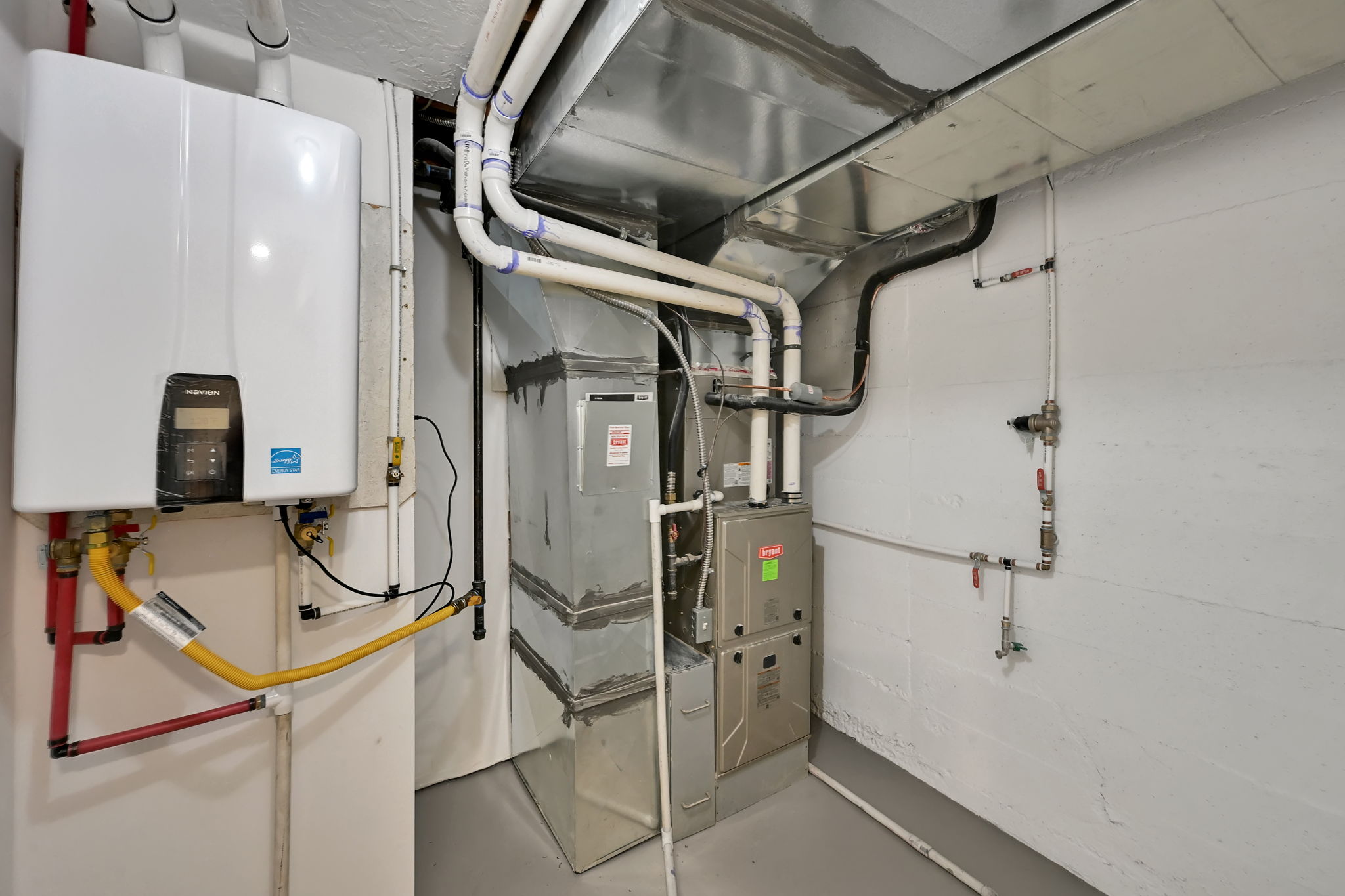 Utility room with tankless water heater and new furnace