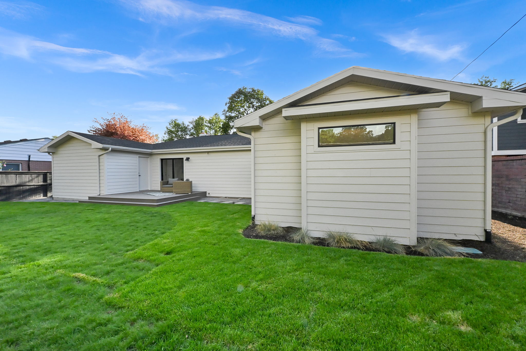 Back of home- expansive green lawn with a composite deck