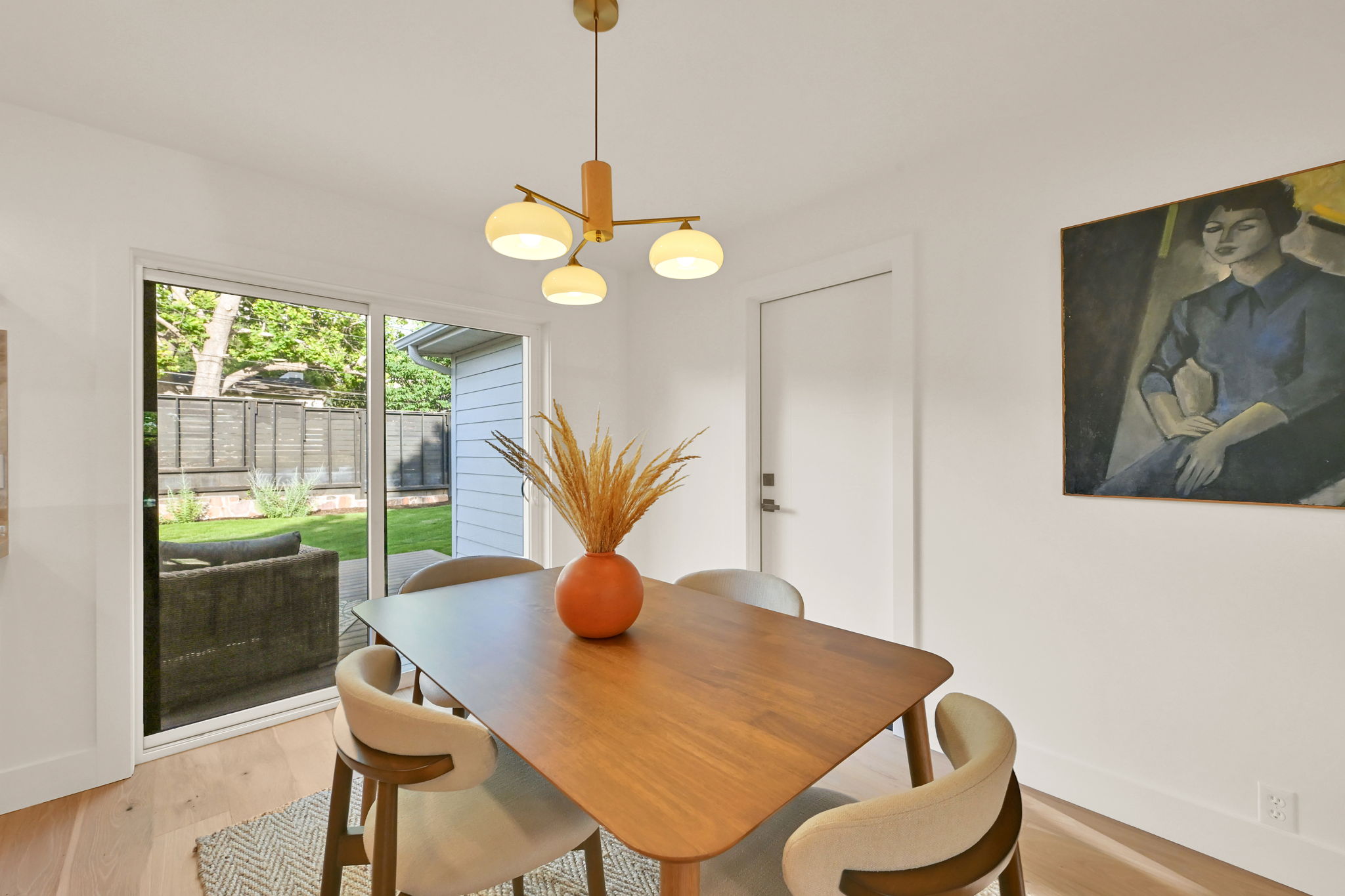Dining area featuring wood-finish flooring, a contemporary chandelier, and a sliding glass door providing access to the outdoor space