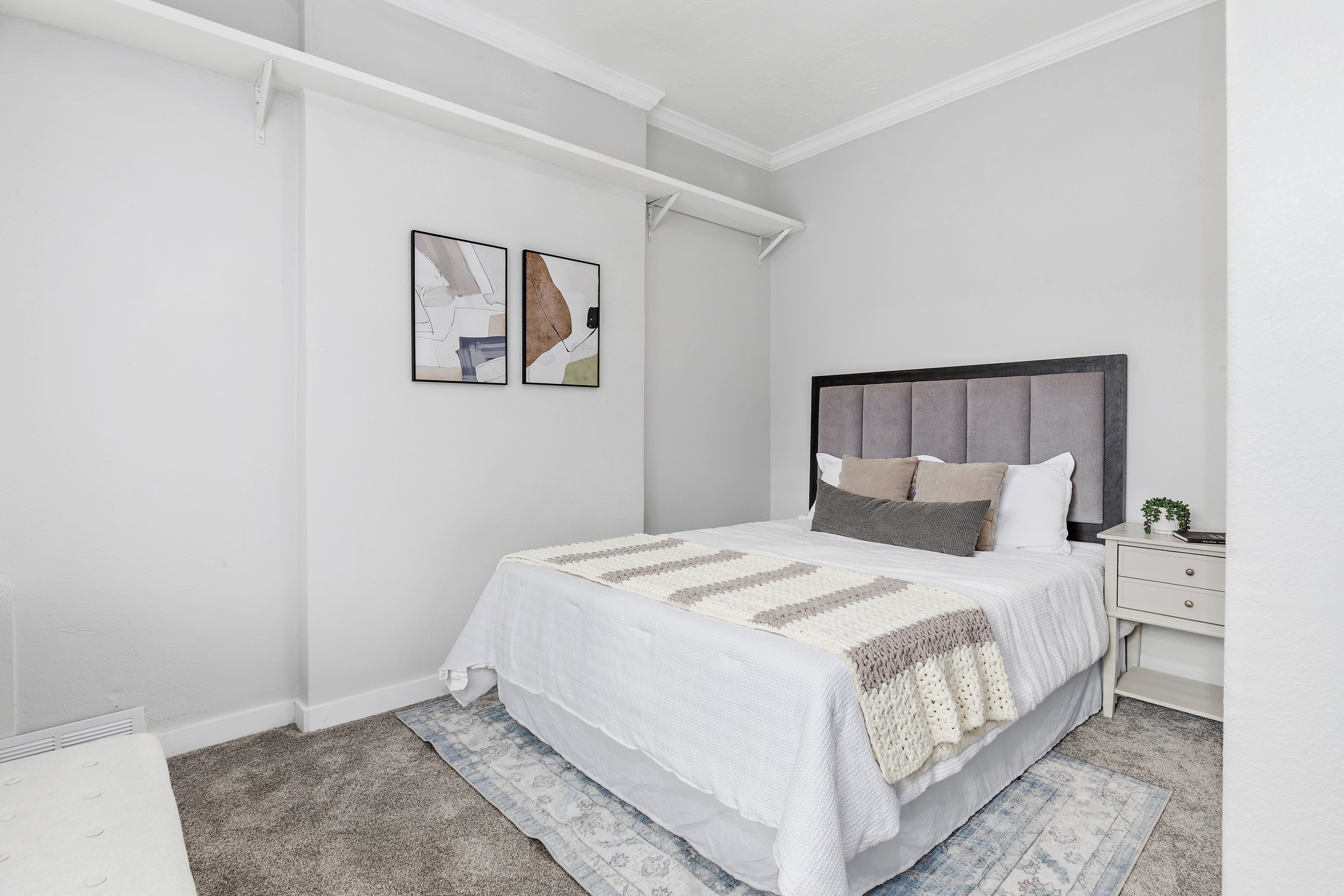 Bedroom featuring neutral wall colors, crown molding, gray carpeting, and a built-in closet shelf system