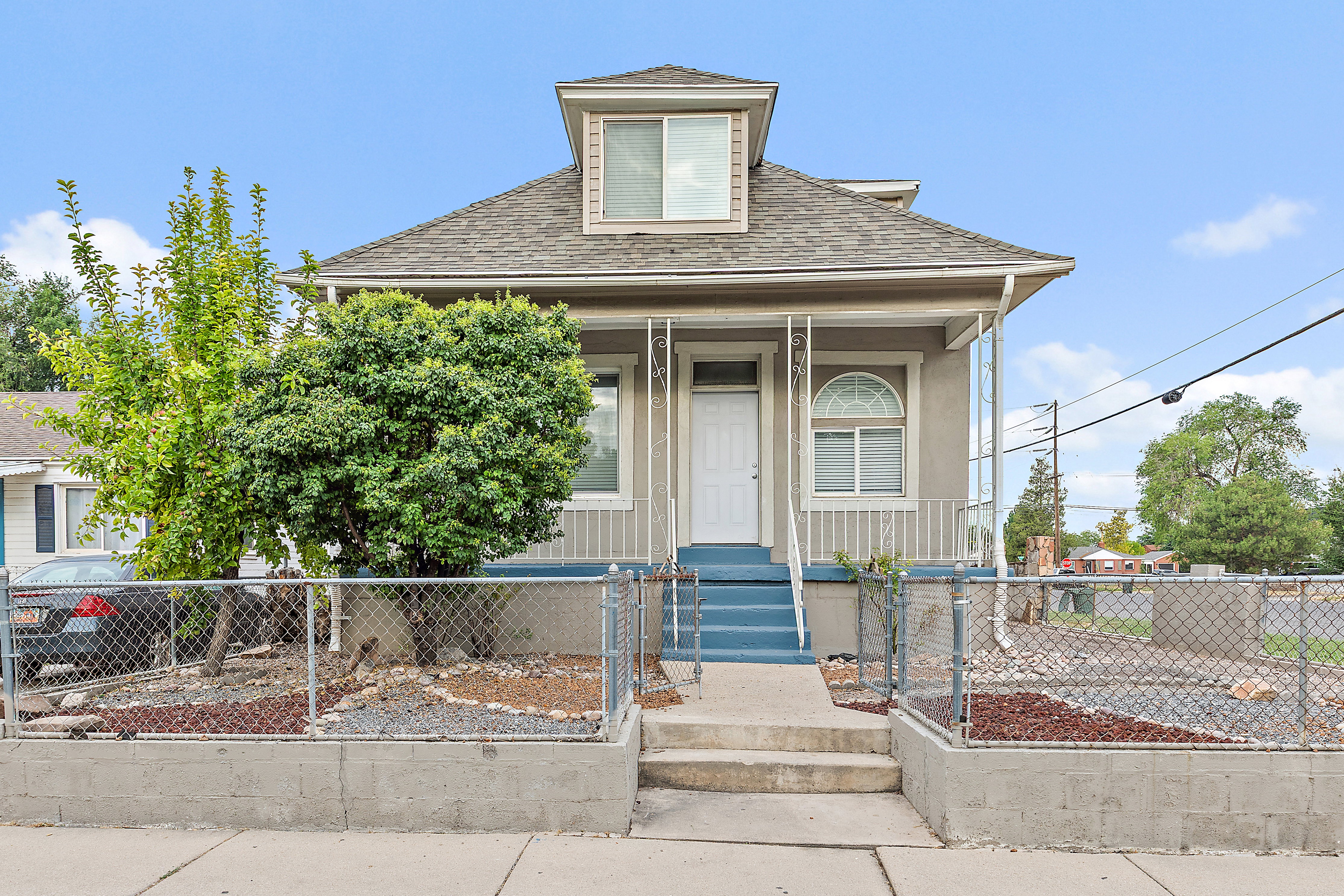 Exterior featuring a dormer window, covered porch, and blue steps