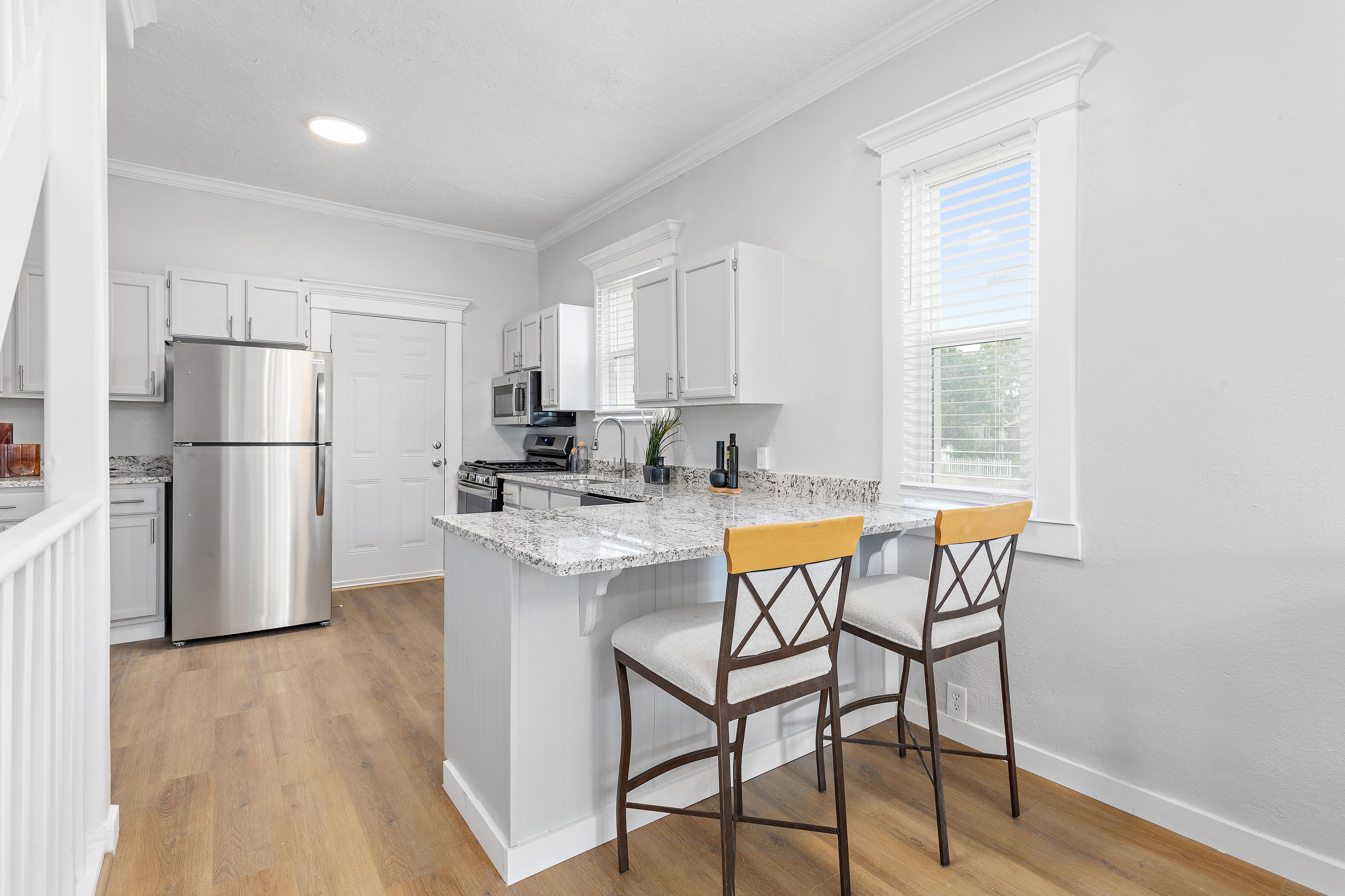 Kitchen featuring wood-finish flooring, light grey cabinetry, and speckled countertops