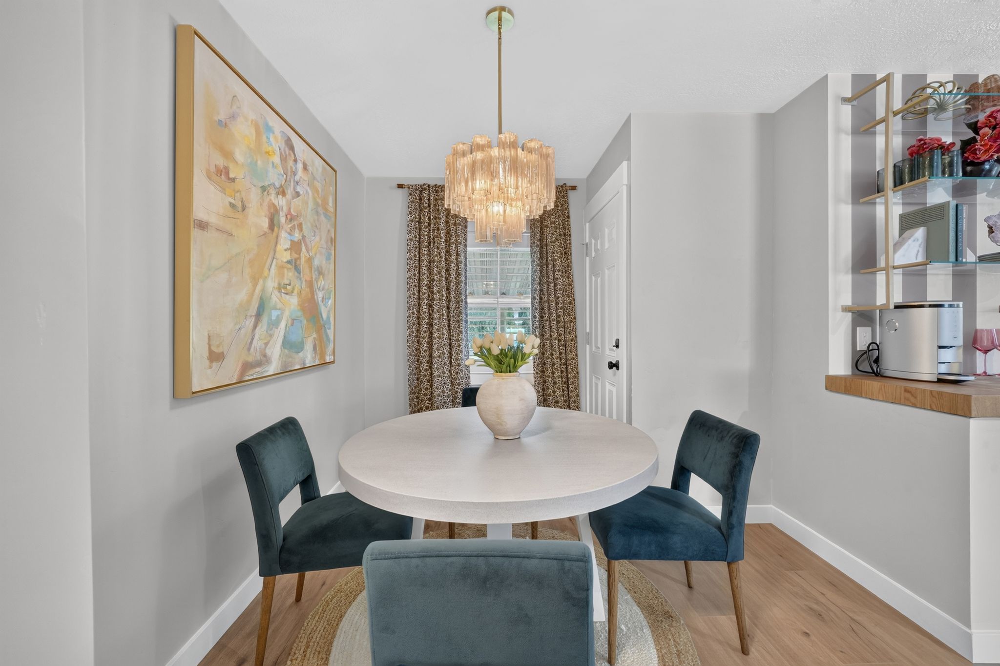 Dining area featuring a contemporary chandelier, wood-finish flooring, a built-in shelf unit, an exterior door, and a window with patterned drapes