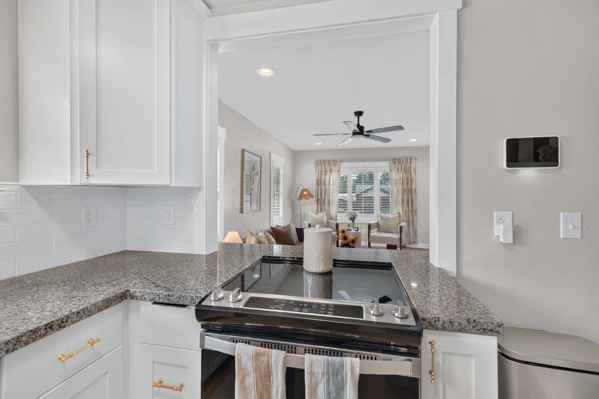 Modern kitchen featuring white shaker cabinetry, granite-finish countertops, and a white subway tile backsplash