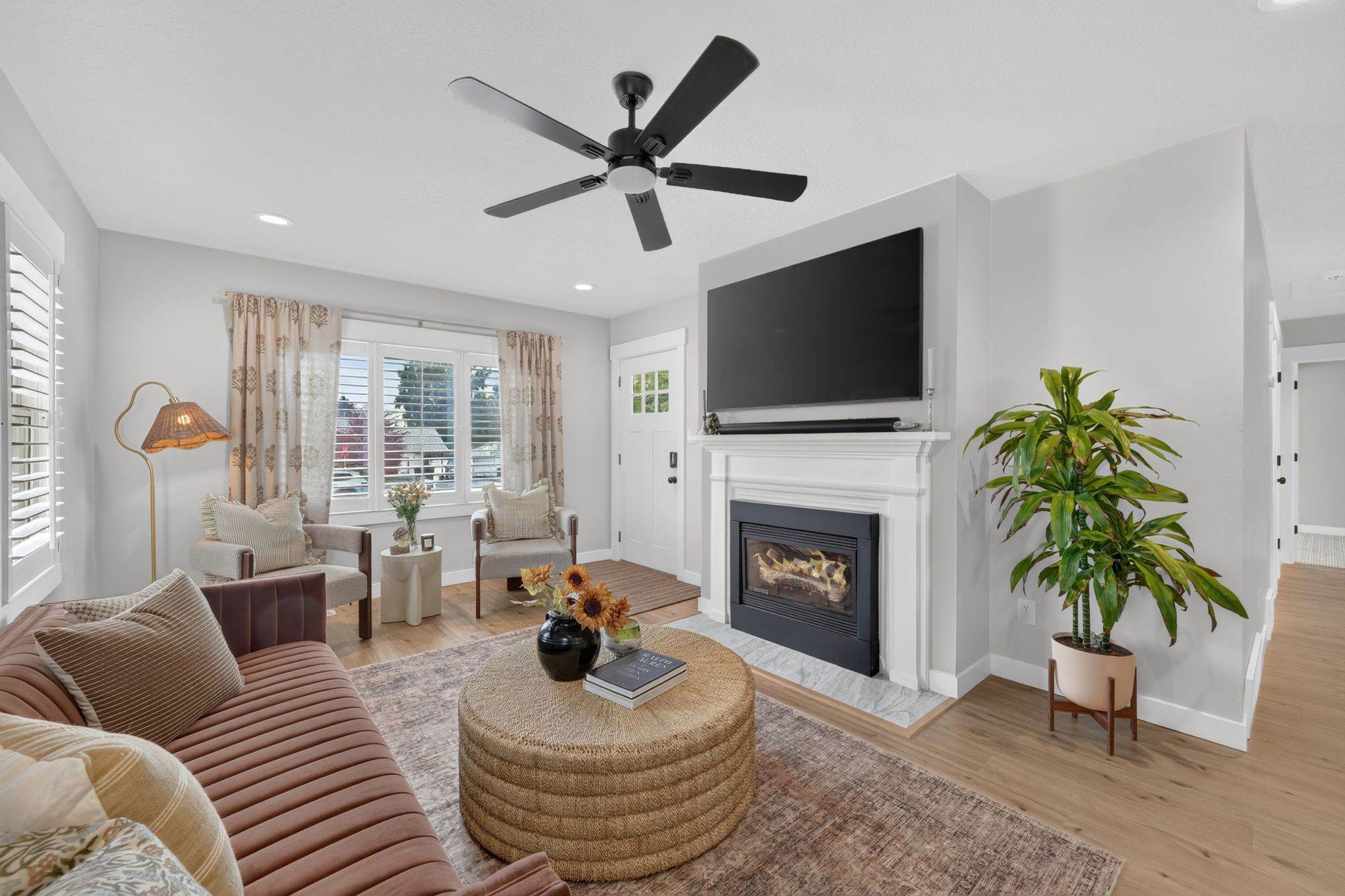 Living area featuring a fireplace with a white mantel and a light-toned tile hearth