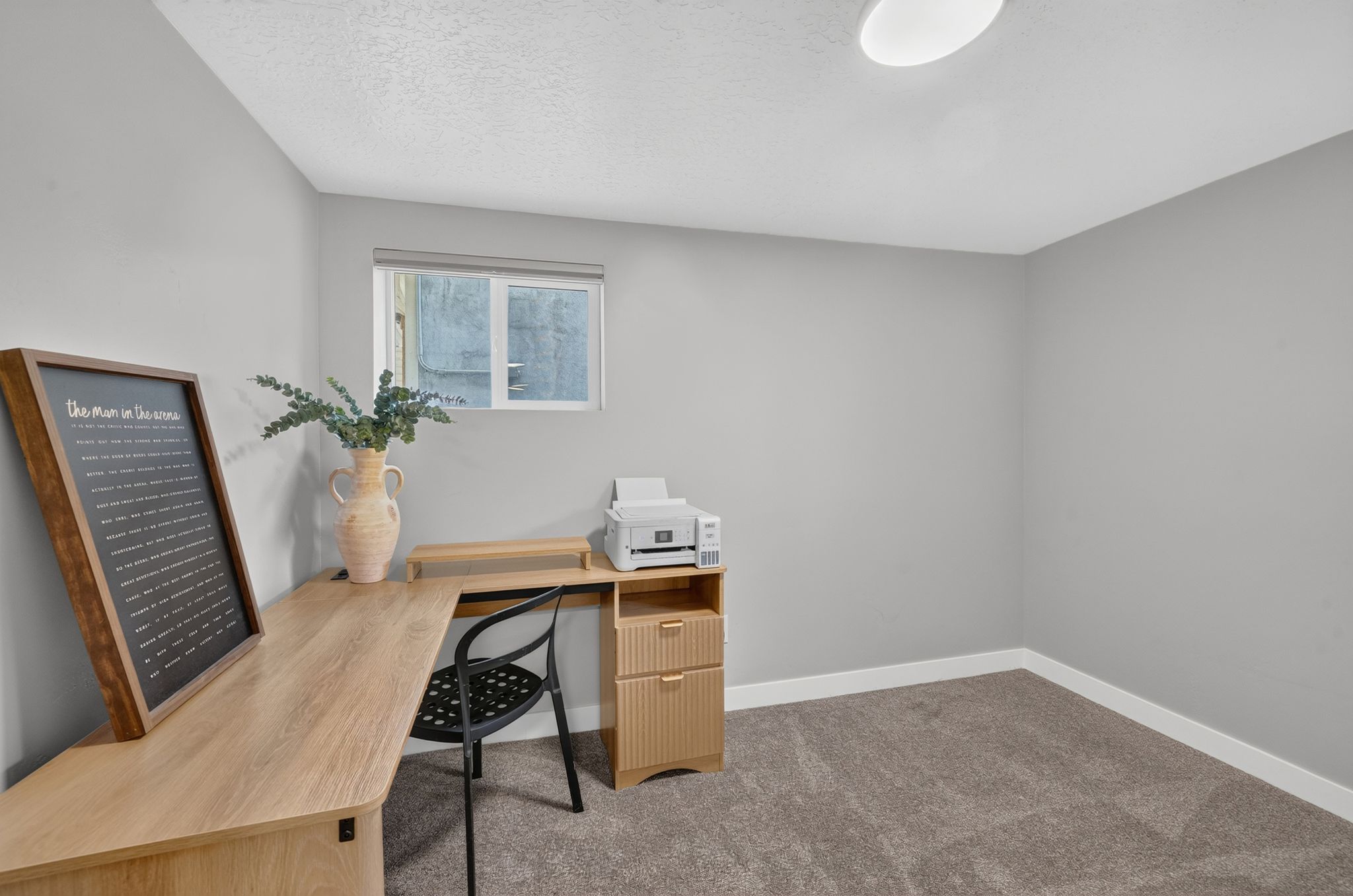 Room featuring neutral gray walls, a window with natural light, and plush gray carpeting