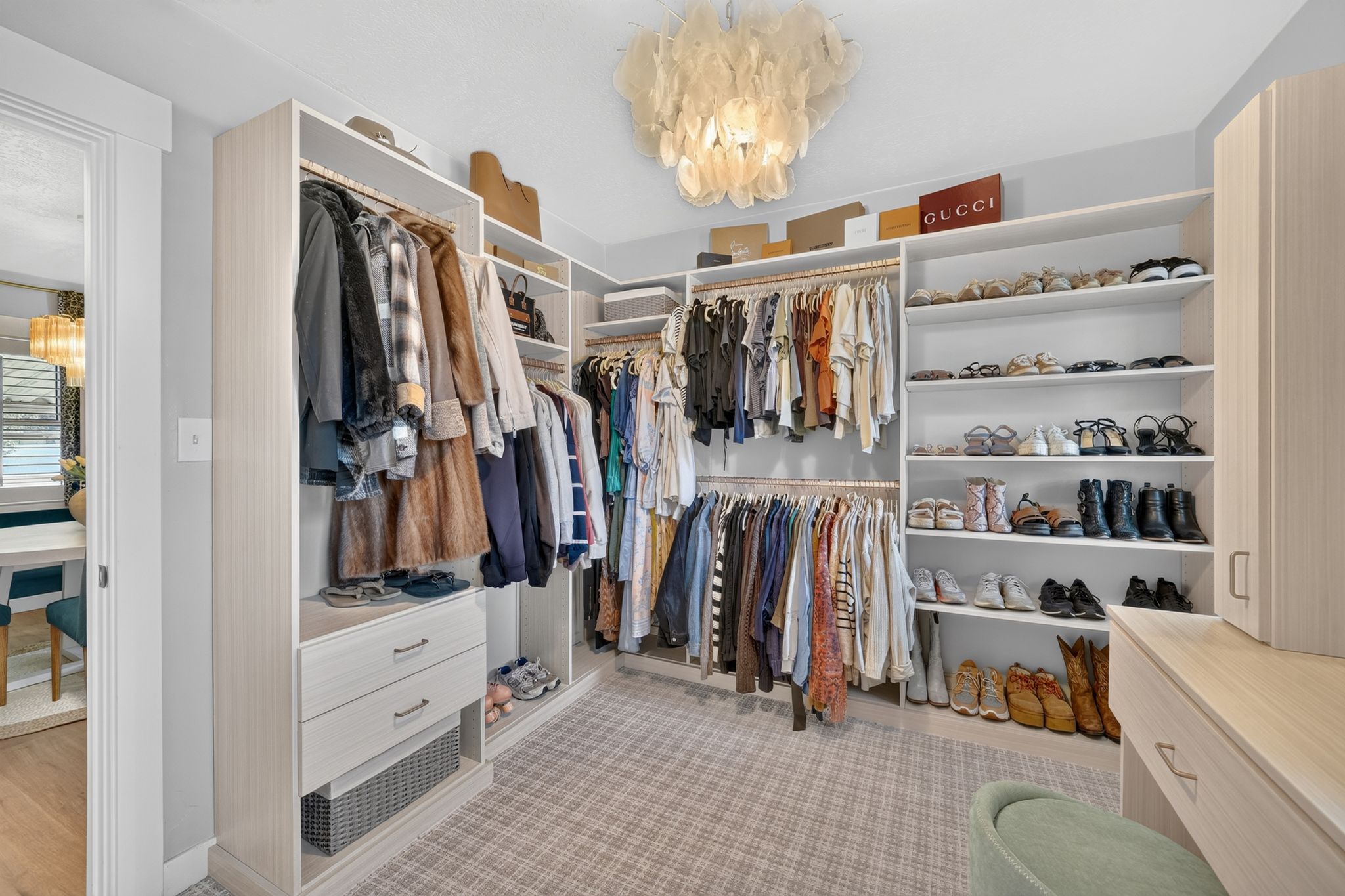 Custom closet system featuring extensive shelving, multiple hanging rods, built-in drawers, and integrated cabinetry