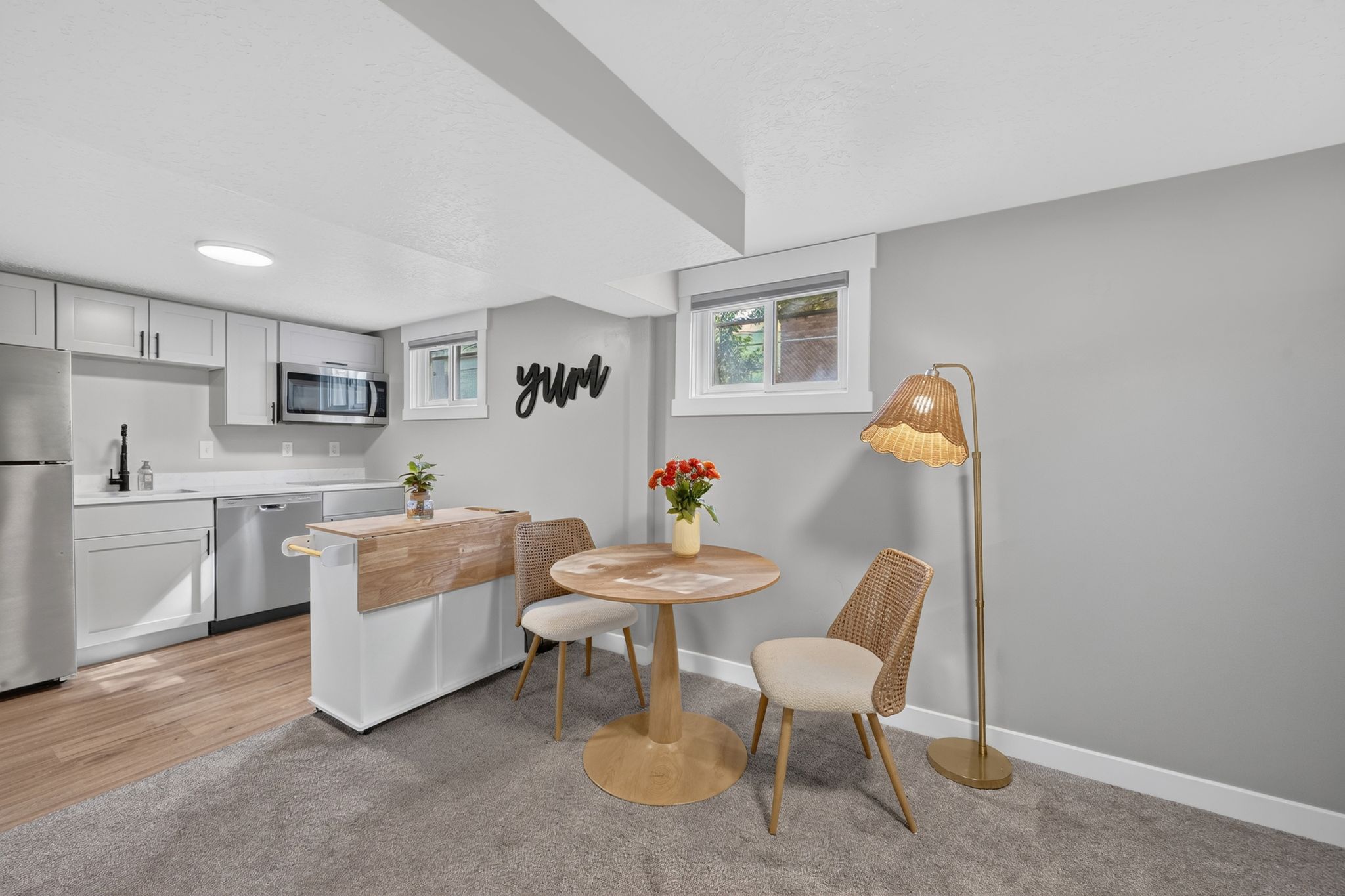 Kitchenette with light gray cabinetry, stainless steel appliances, and a butcher block island