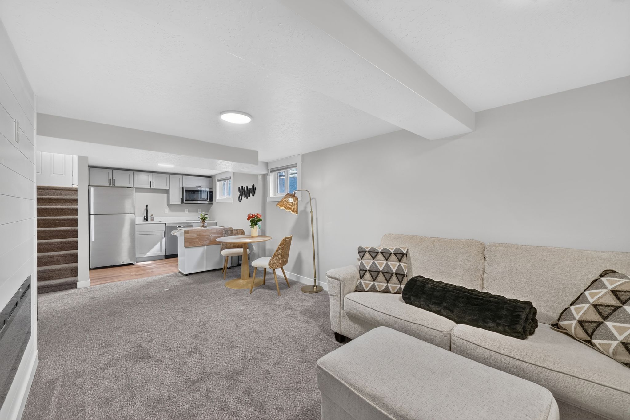 Open-concept living area featuring a kitchen with stainless steel appliances, a built-in microwave, and light-toned cabinetry