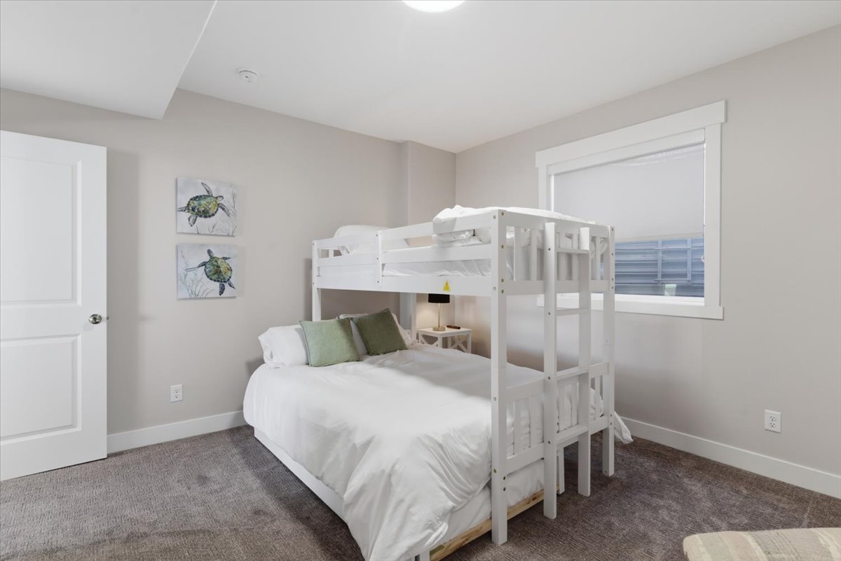 Bedroom featuring a bunk bed frame, neutral wall paint, and gray carpet flooring