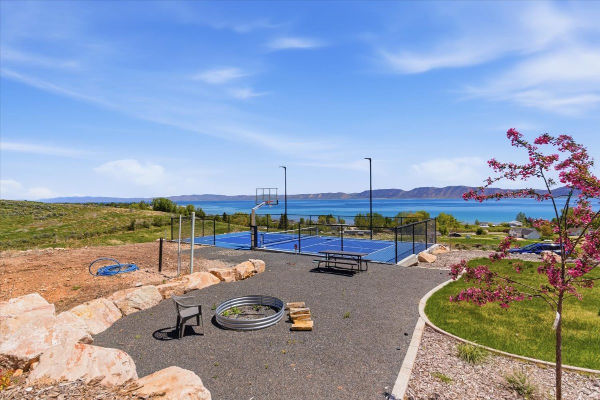 Multi-sport court with blue surfacing, surrounded by black fencing, and featuring basketball hoops