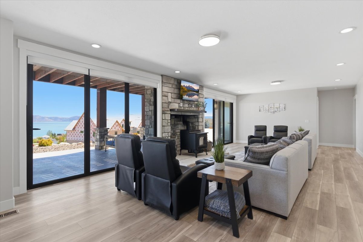 Spacious interior featuring wood-finish flooring and a stone fireplace with a wood-burning stove
