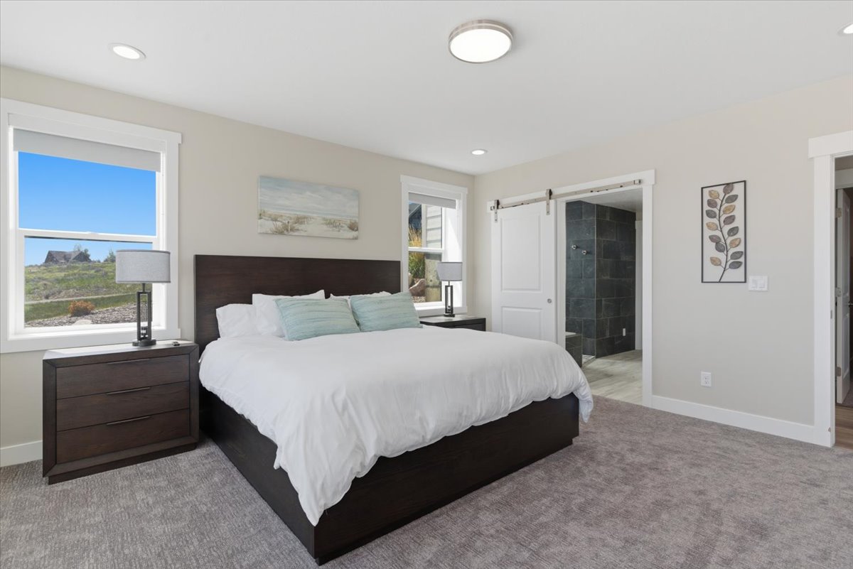 Light-filled bedroom featuring recessed lighting, a ceiling-mounted fixture, and two double-hung windows