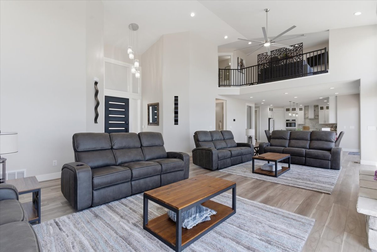 Spacious living area featuring high ceilings, wood-finish flooring, and an open loft