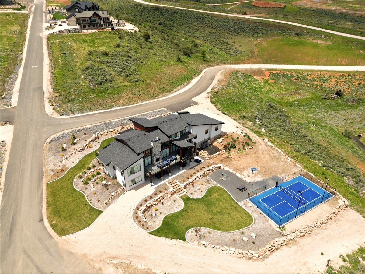Contemporary residence featuring a multi-level design with a dark shingle roof and a stone-clad chimney