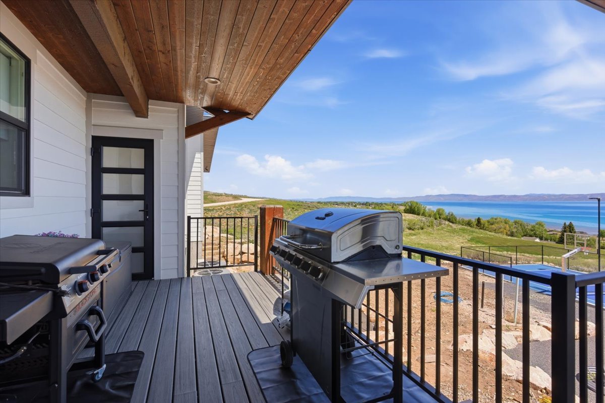 Expansive outdoor deck featuring wood-finish decking, a black metal railing, and a wood-paneled ceiling