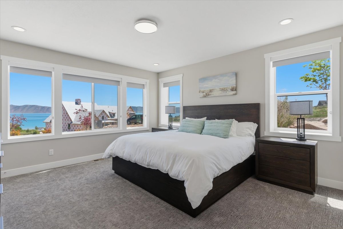 Expansive windows with roller shades framing a mountain lake backdrop