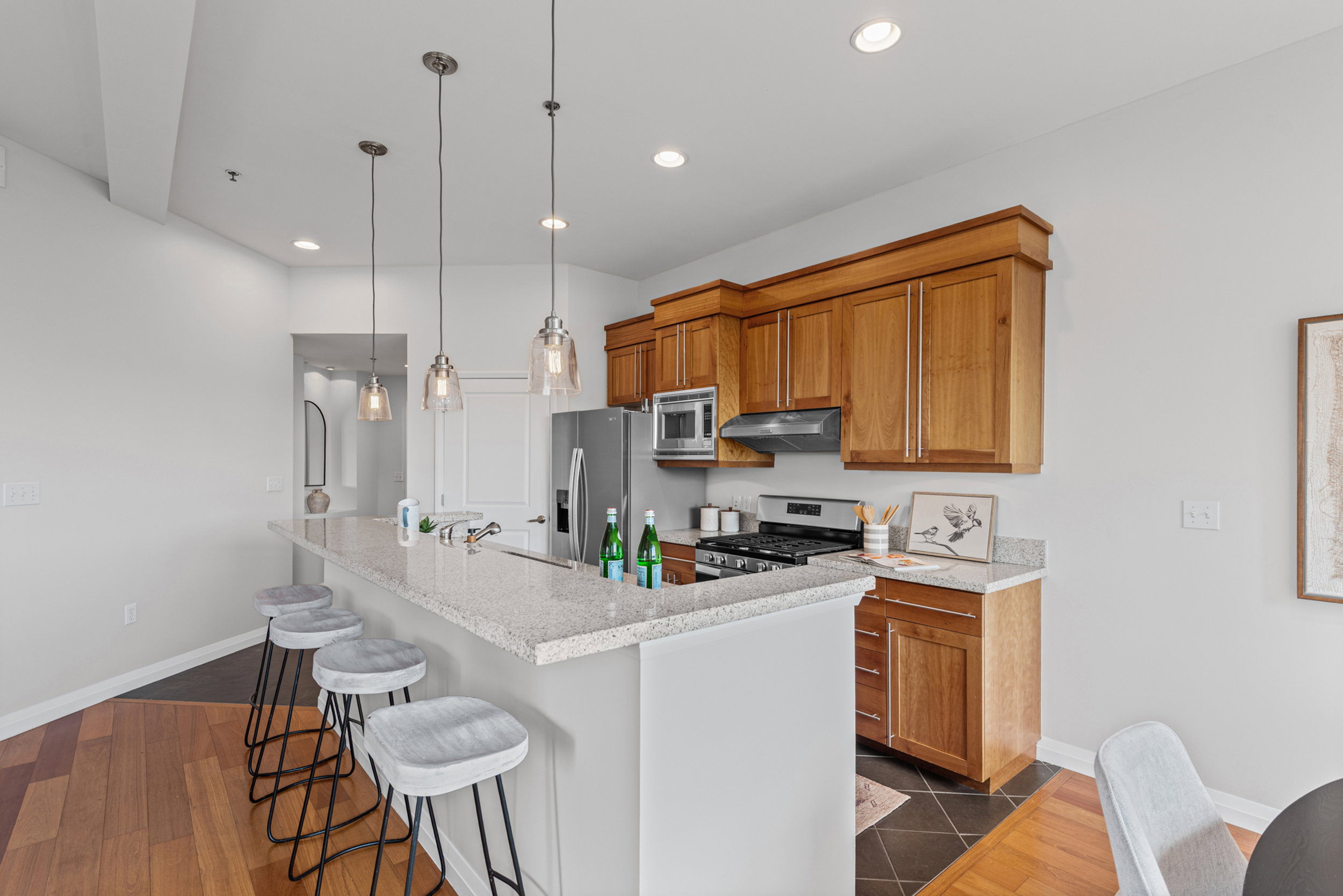 Kitchen featuring light wood cabinetry, stainless steel appliances, and a gas range