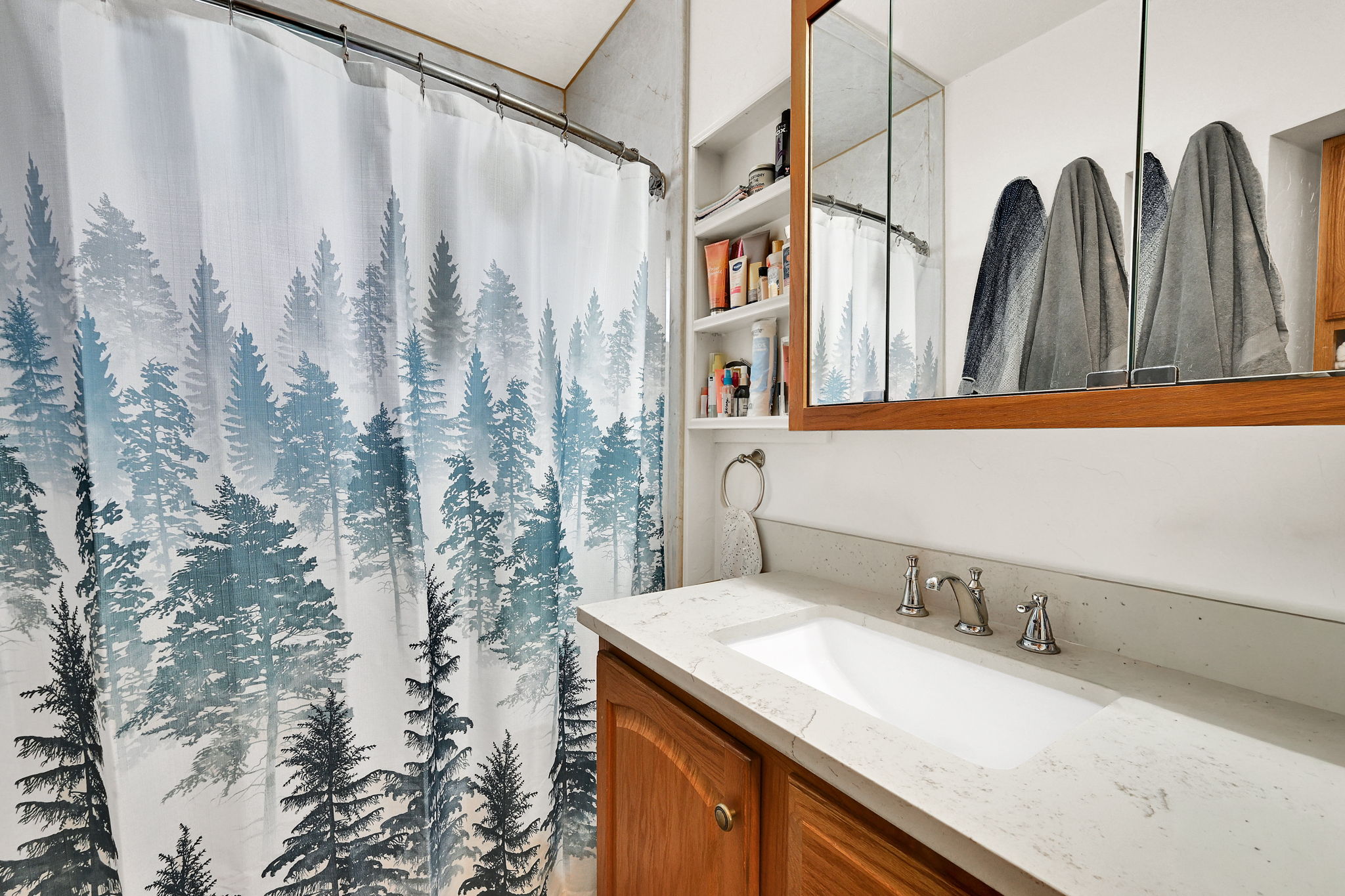 Bathroom featuring a wood vanity with a light-colored countertop and an integrated sink