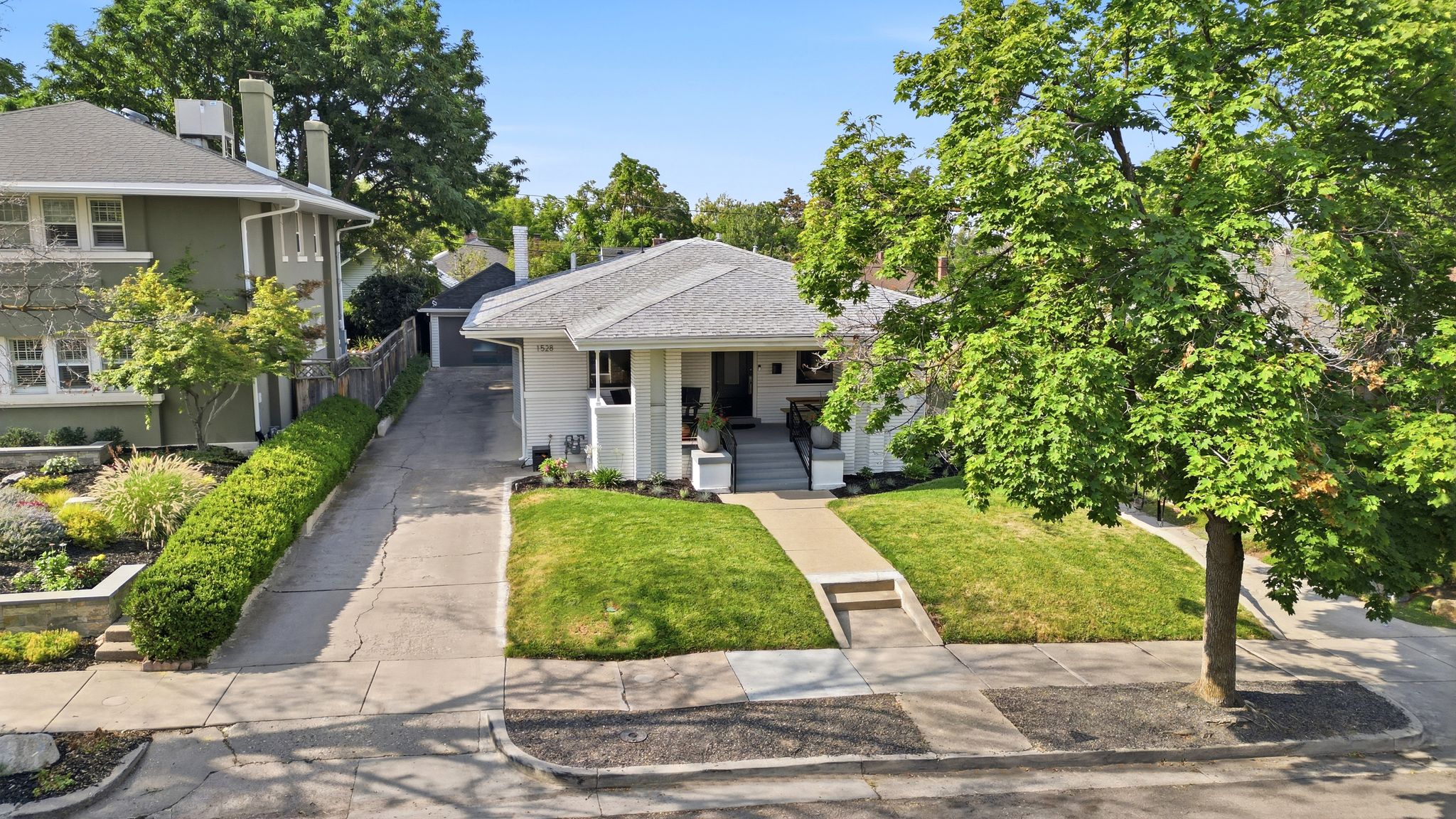 Charming single-story residence with a light-colored exterior and a gray shingle roof