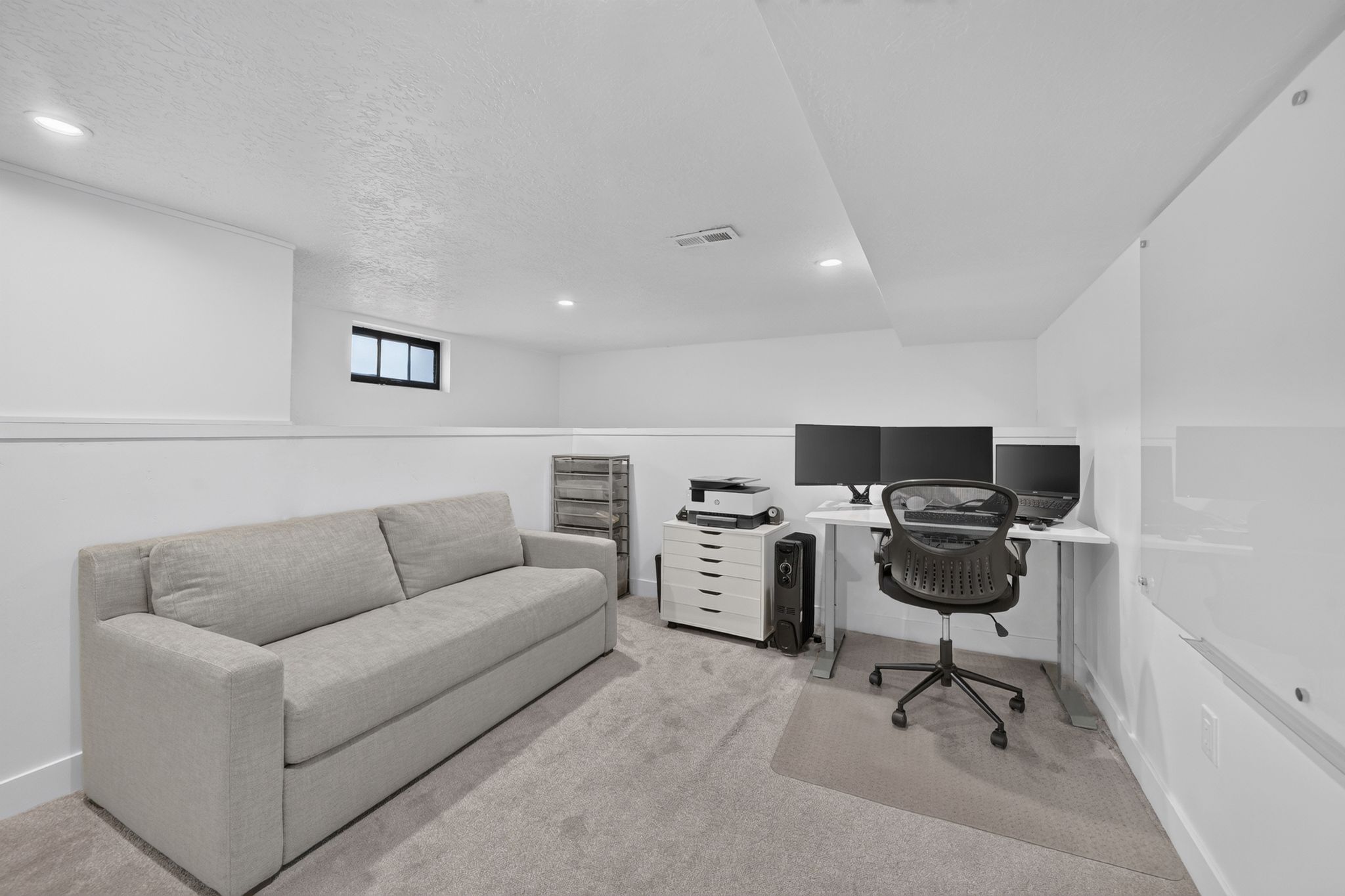 Carpeted room with recessed lighting and a window