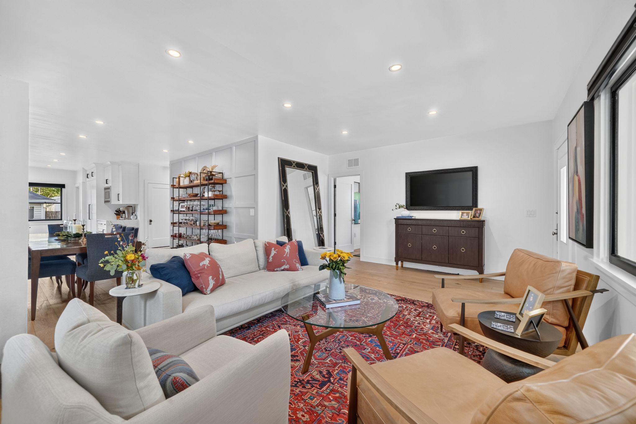 Open-concept living area with light wood-finish flooring and recessed lighting