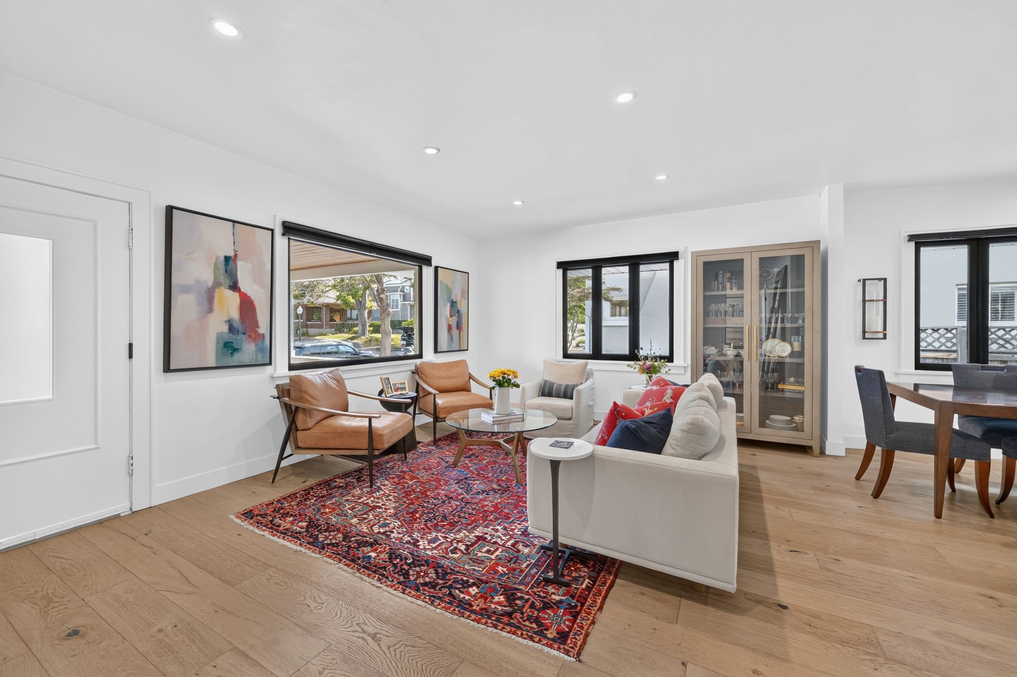 Open-concept living area featuring wood-finish flooring, recessed lighting, and expansive windows with black trim