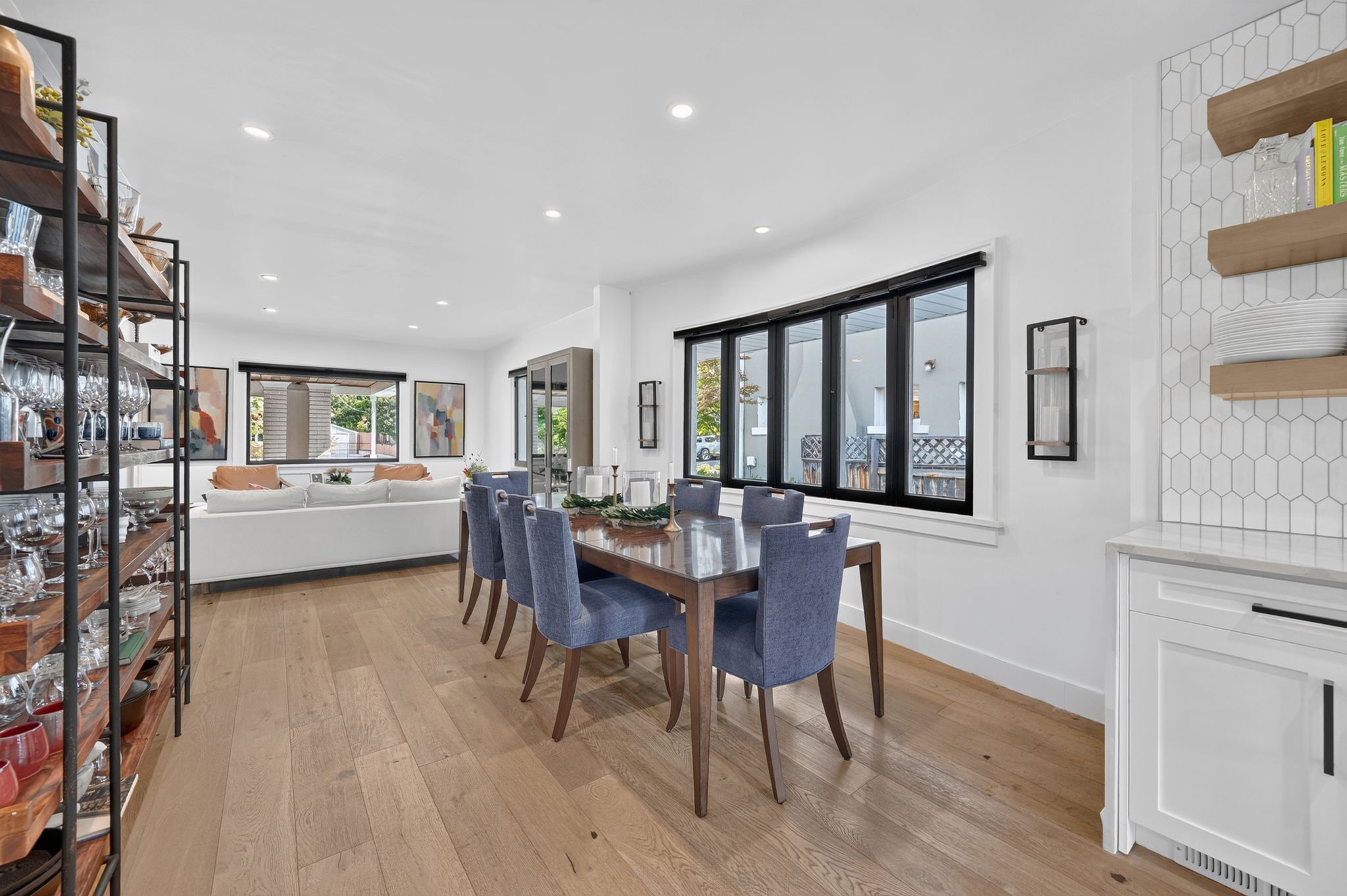 Open-concept living space featuring wood-finish flooring, recessed lighting, and large windows with black frames