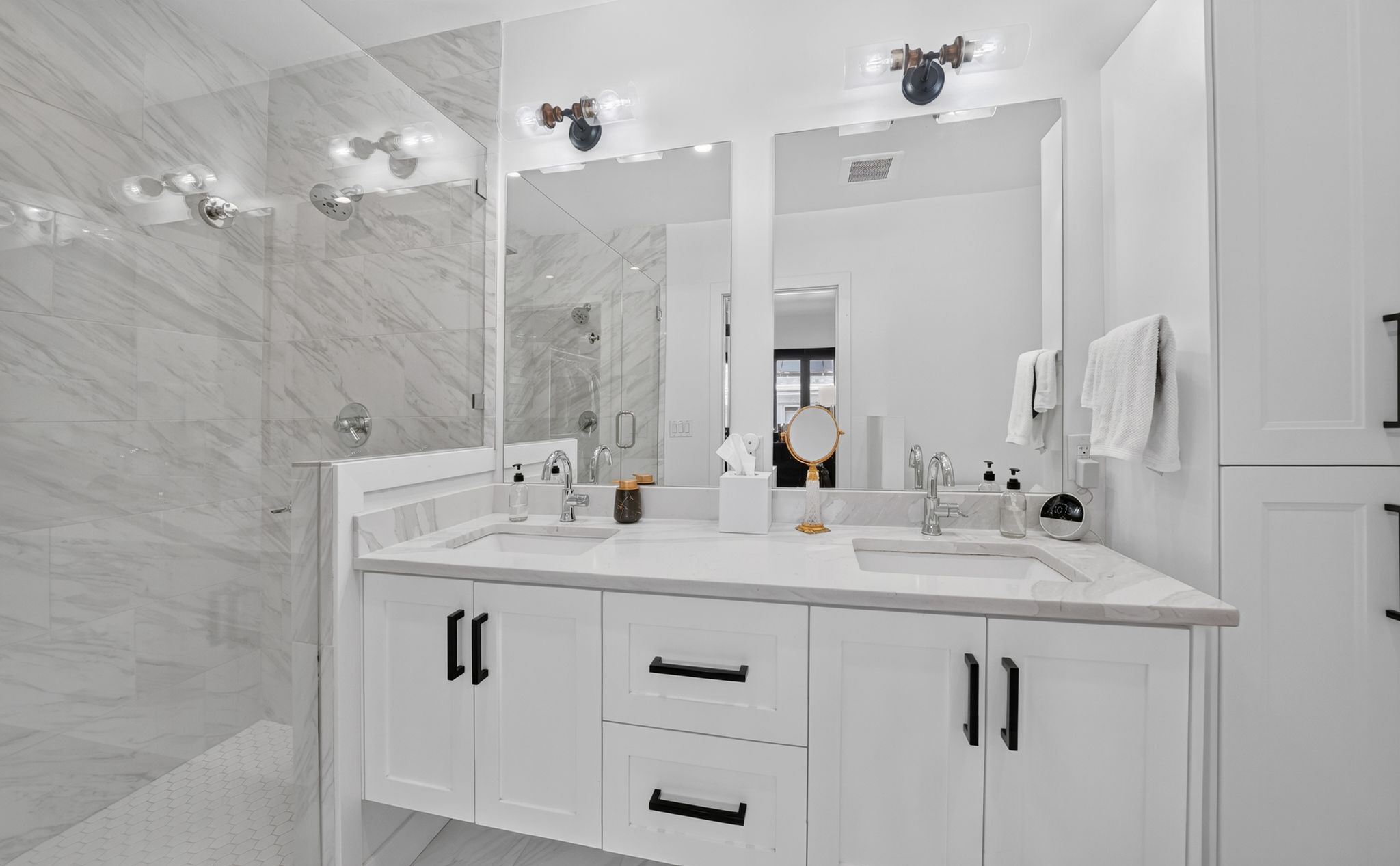 Dual vanity with white cabinetry, matte black hardware, and an integrated countertop with undermount sinks