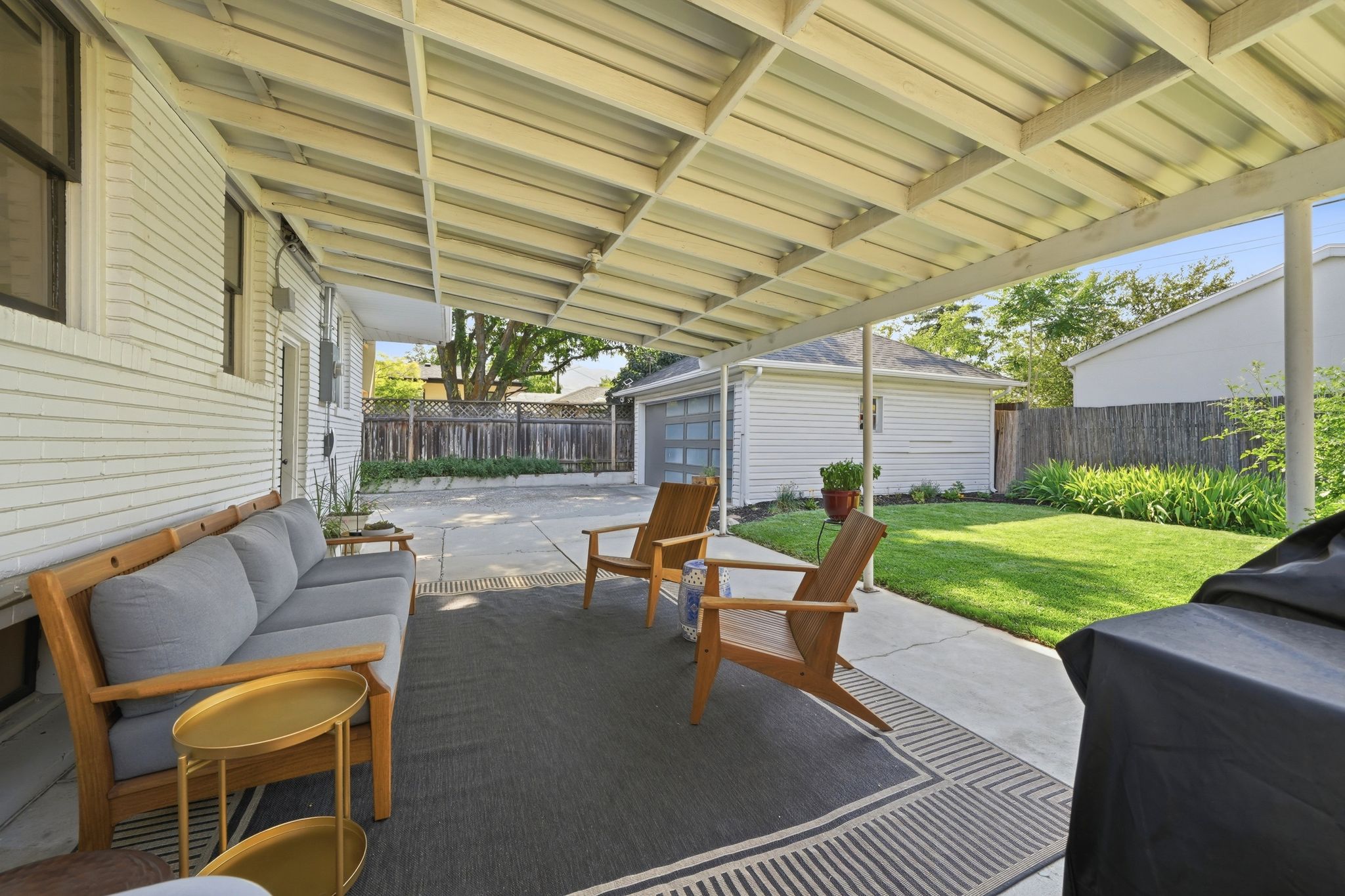 Covered patio area featuring a concrete slab and a corrugated metal roof