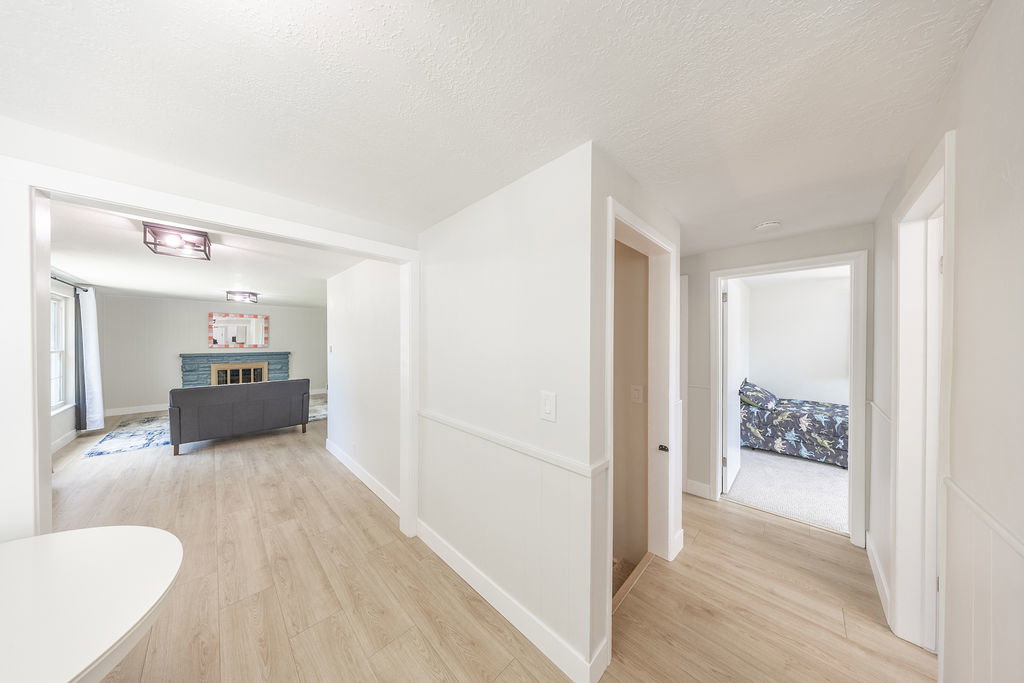 Light wood-finish flooring throughout the hallway and living area