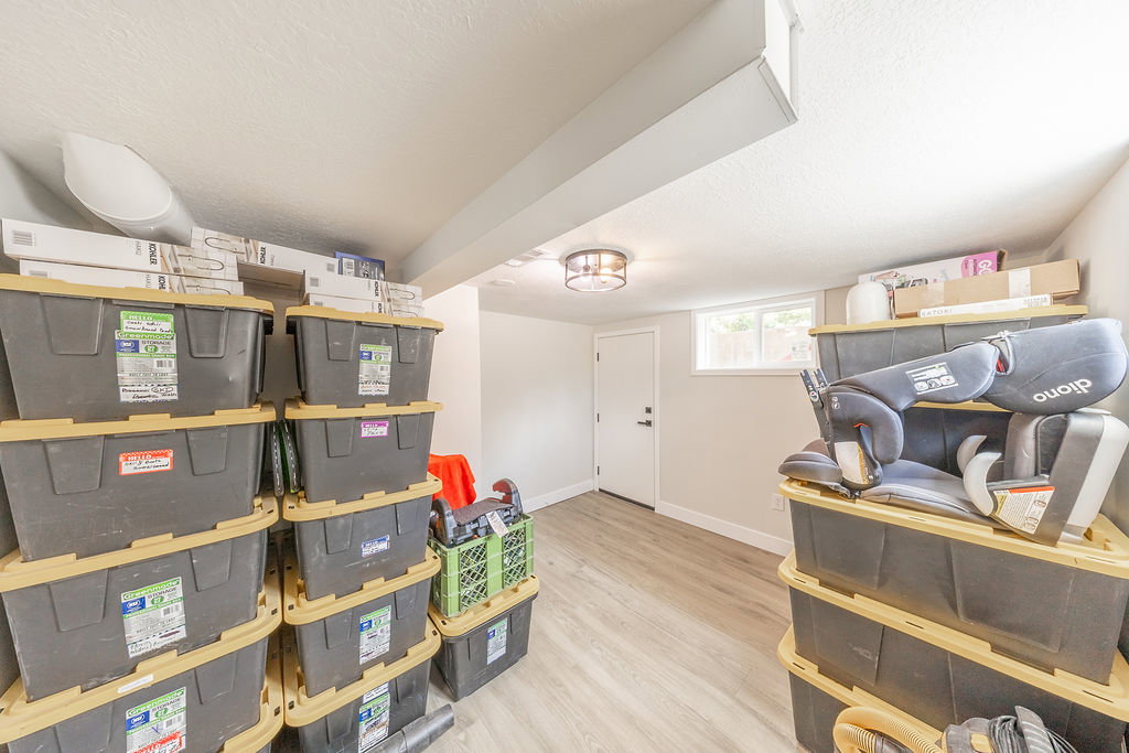 Versatile lower-level space featuring recessed lighting, a window, wood-finish flooring, a white door, and a flush-mount ceiling light