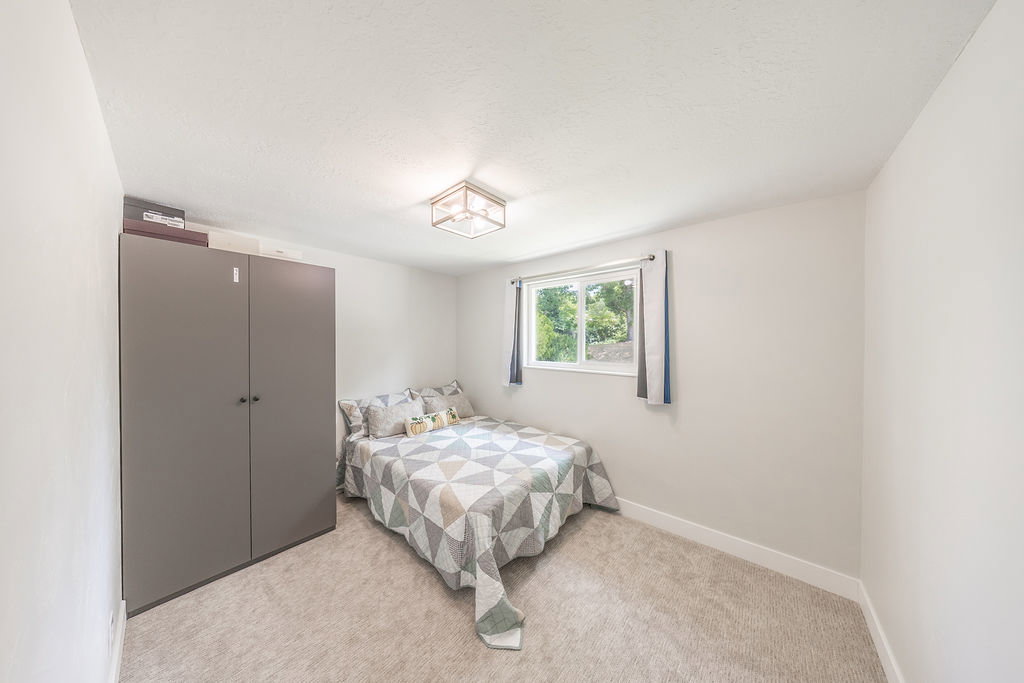 Bedroom with light gray carpeting and white baseboards