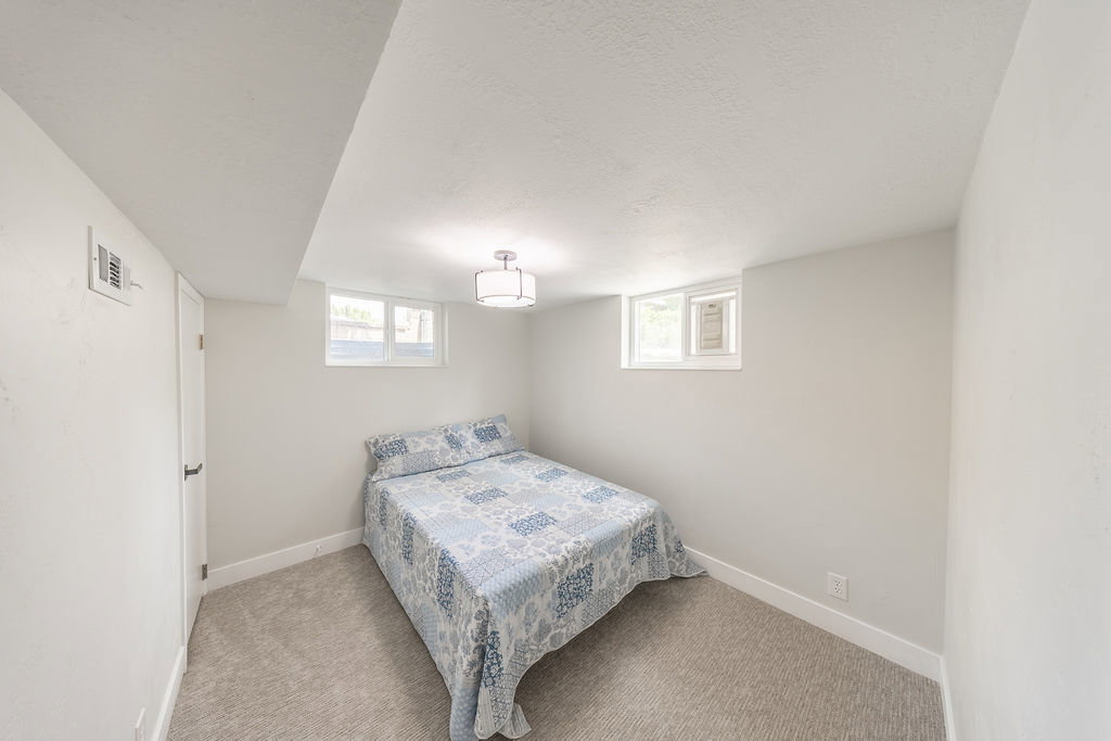 Carpeted room with white walls, a single window, recessed lighting, and a white door