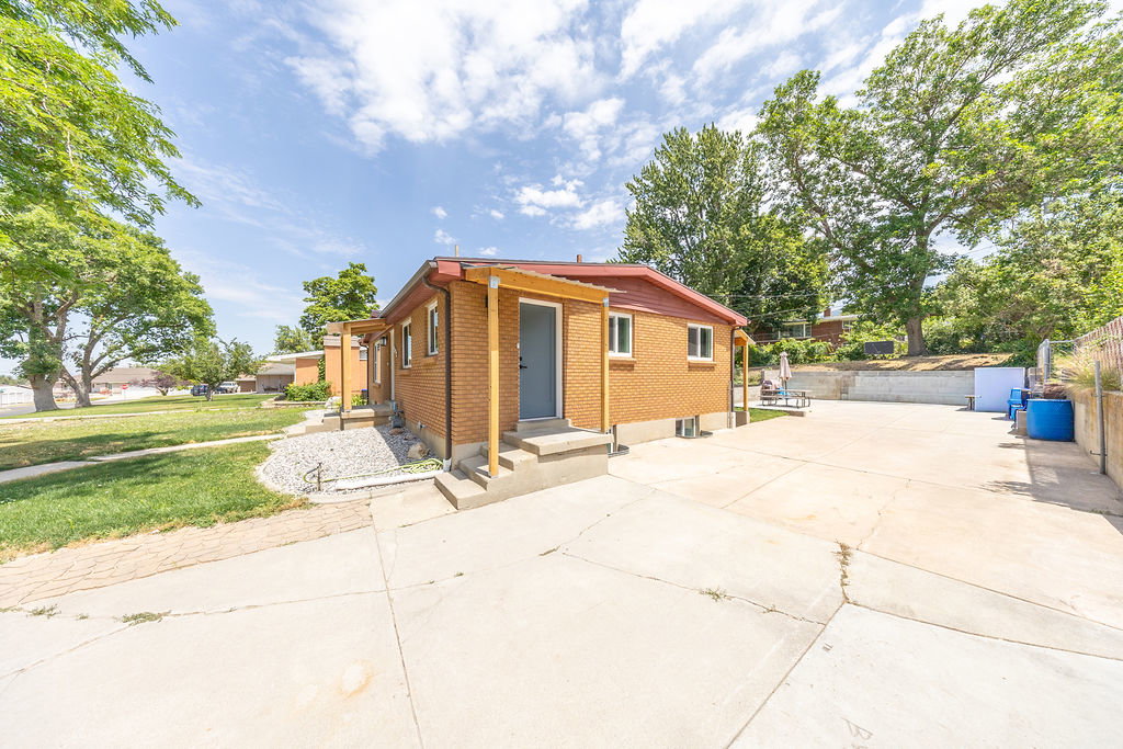 Brick exterior with a covered entry and concrete steps