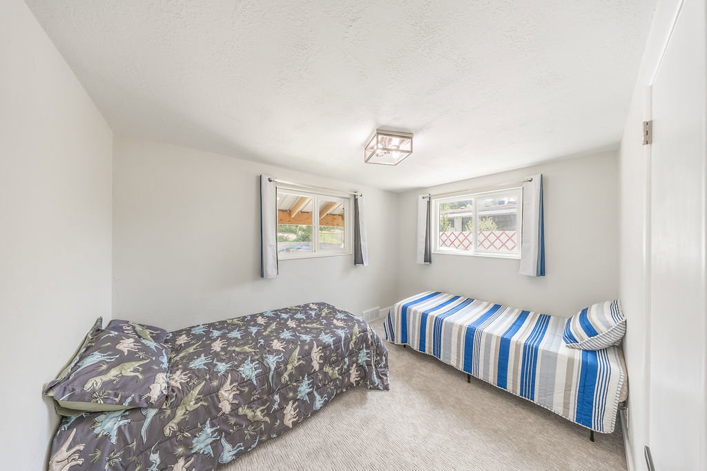 Carpeted room with white walls, two windows, and a flush mount ceiling light fixture