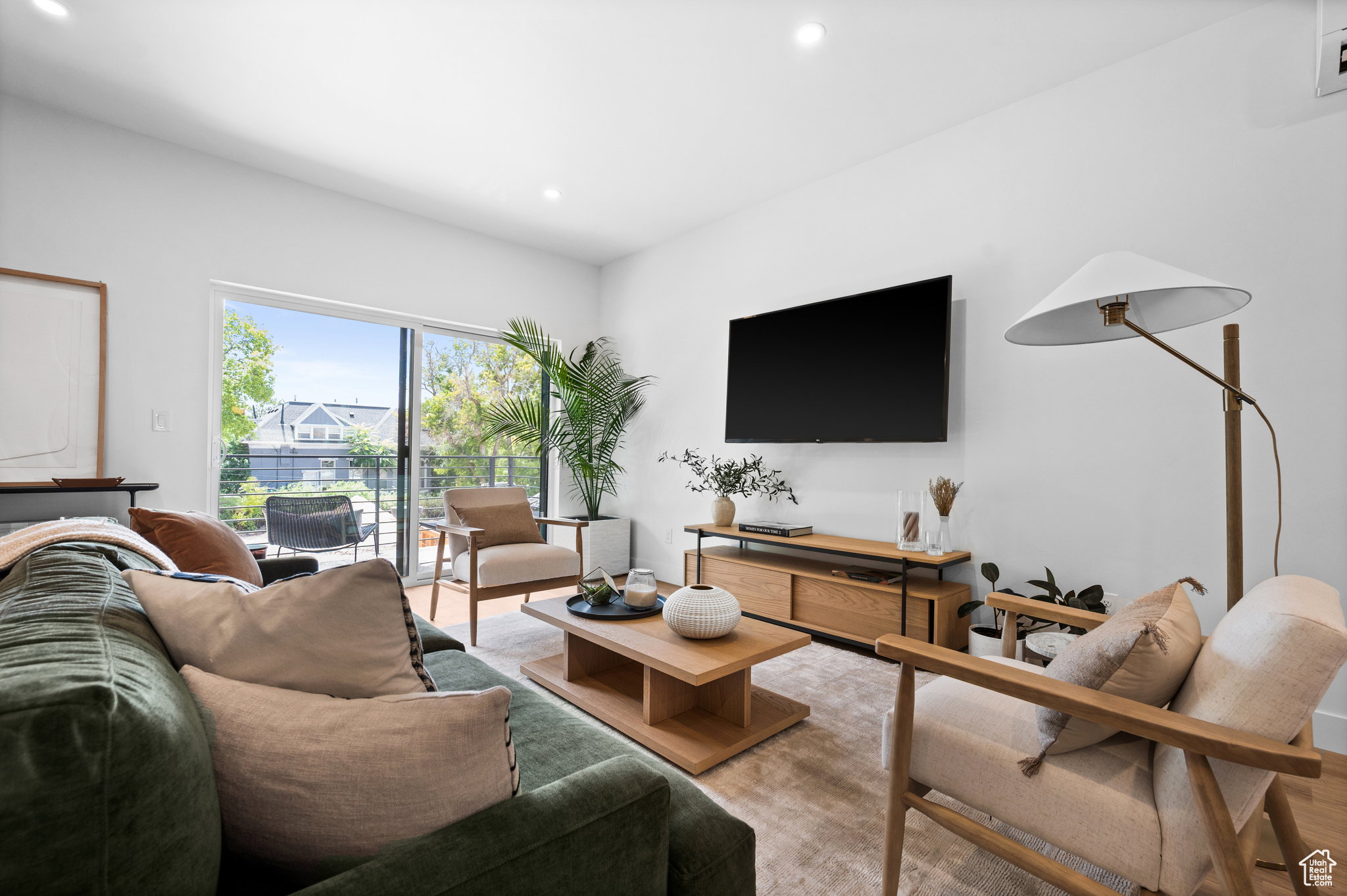 Living area featuring recessed lighting, light wood-finish flooring, and a sliding glass door opening to an outdoor patio