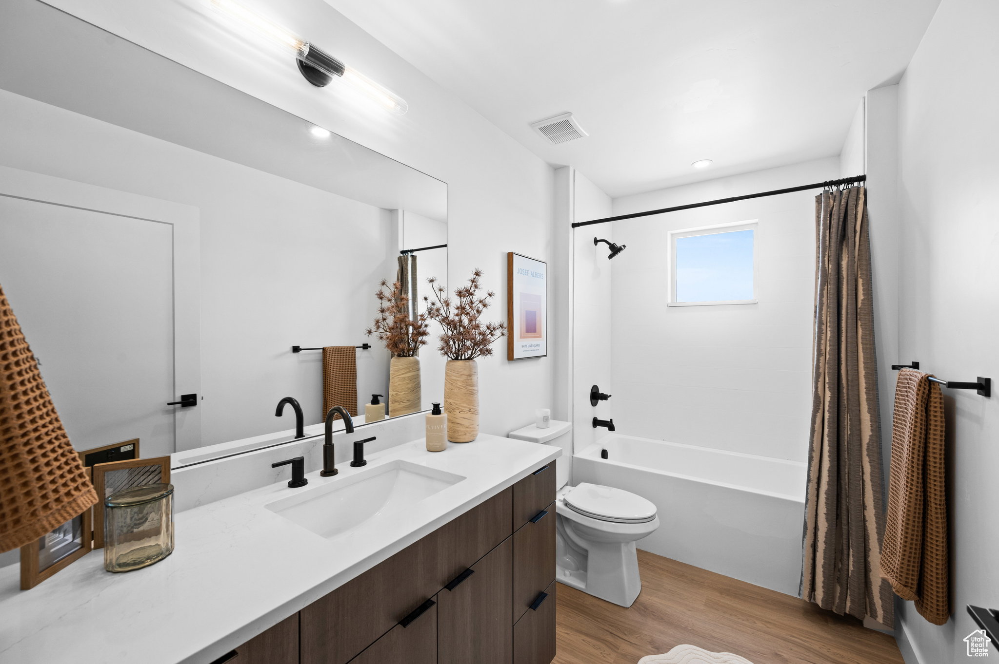 Contemporary bathroom featuring a dark wood-finish vanity with a white countertop and integrated sink