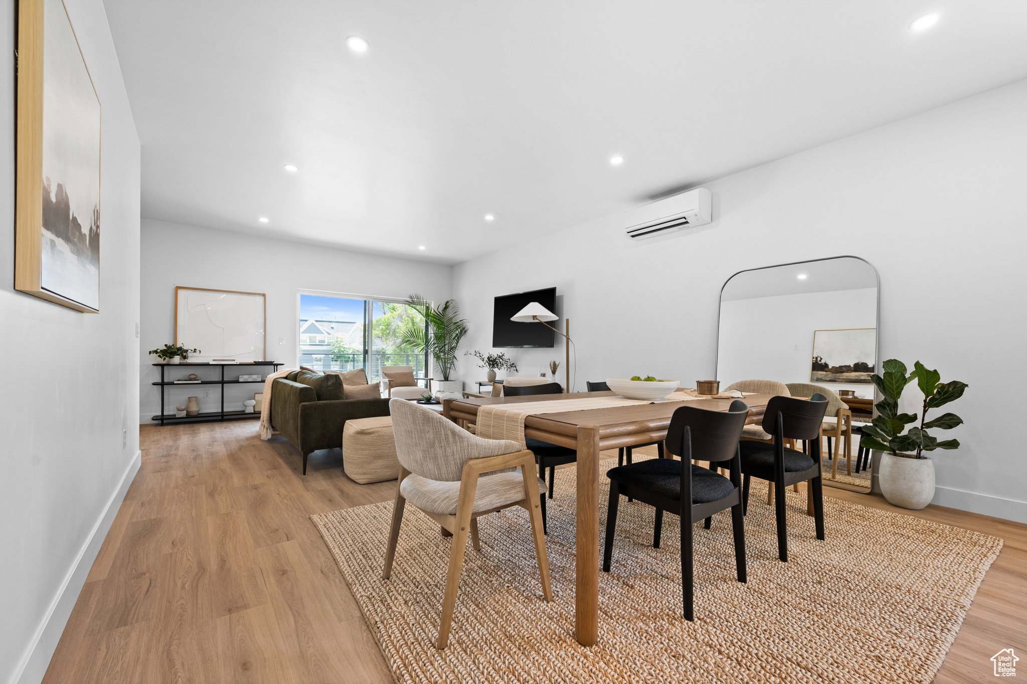 Open concept living and dining area featuring wood-finish flooring, recessed lighting, and a sliding glass door