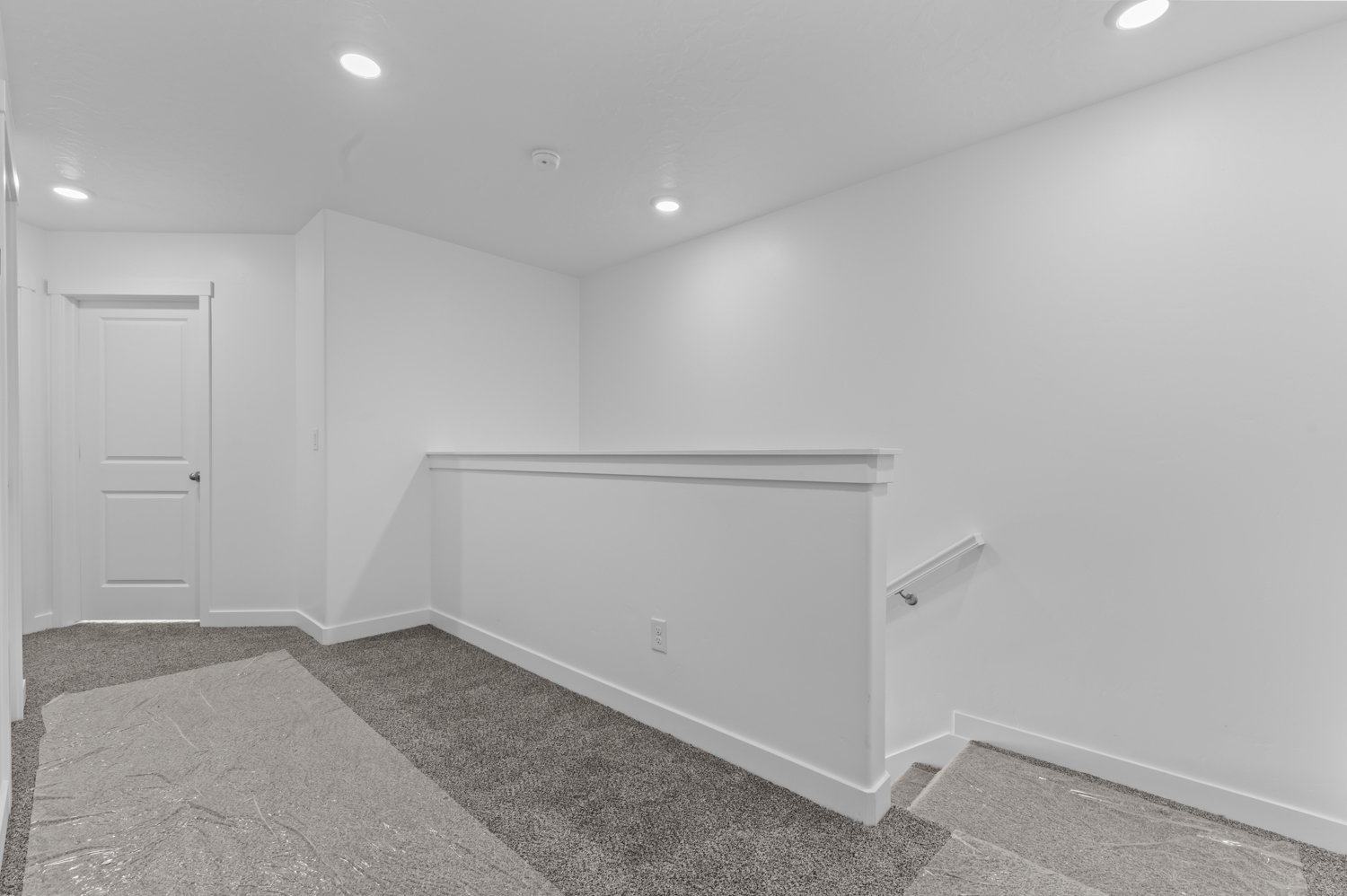 Carpeted landing featuring recessed lighting, white walls, and a white interior door with a silver knob