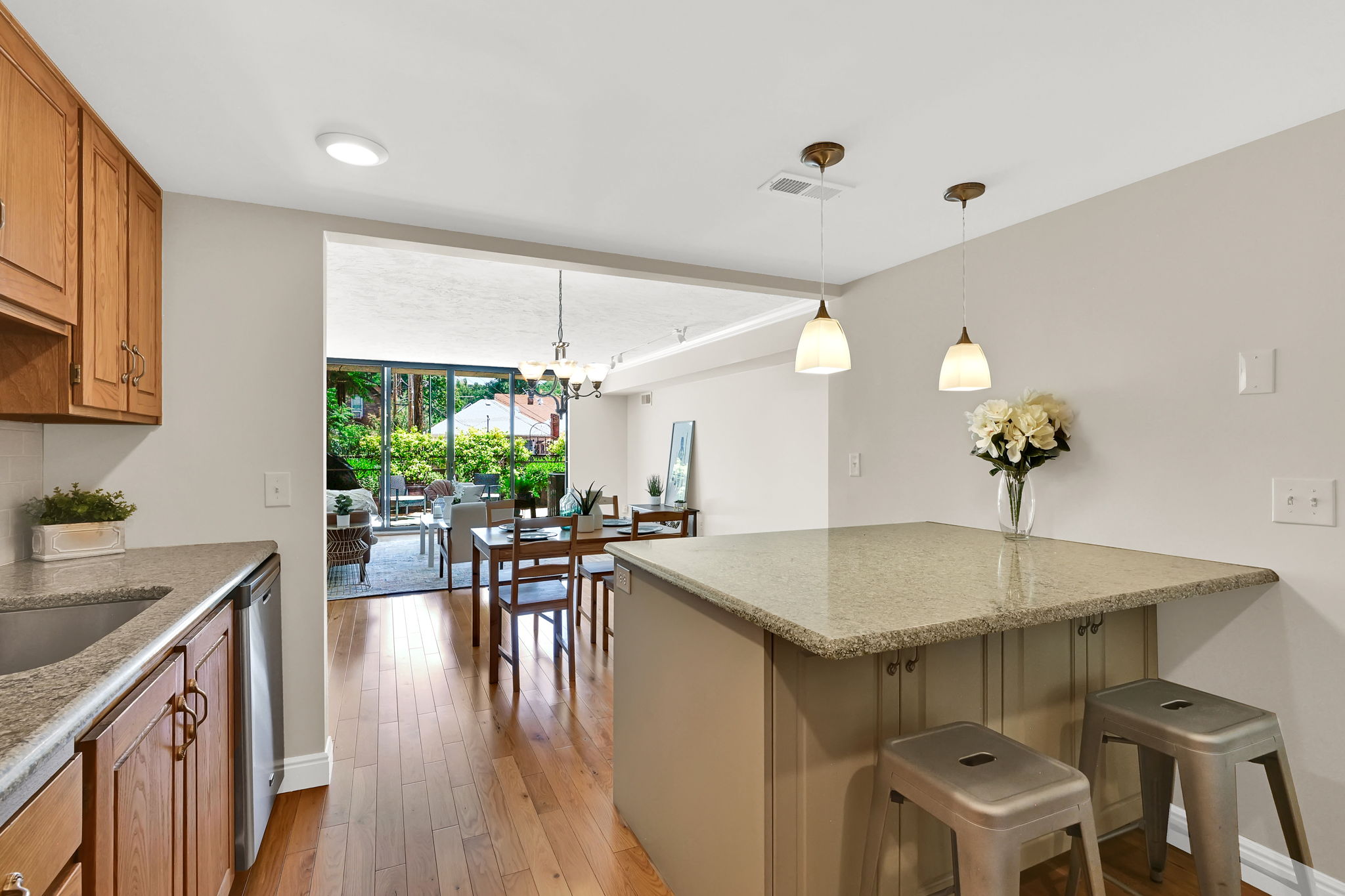 Kitchen featuring granite-style countertops, wood cabinetry, and a central island with pendant lighting