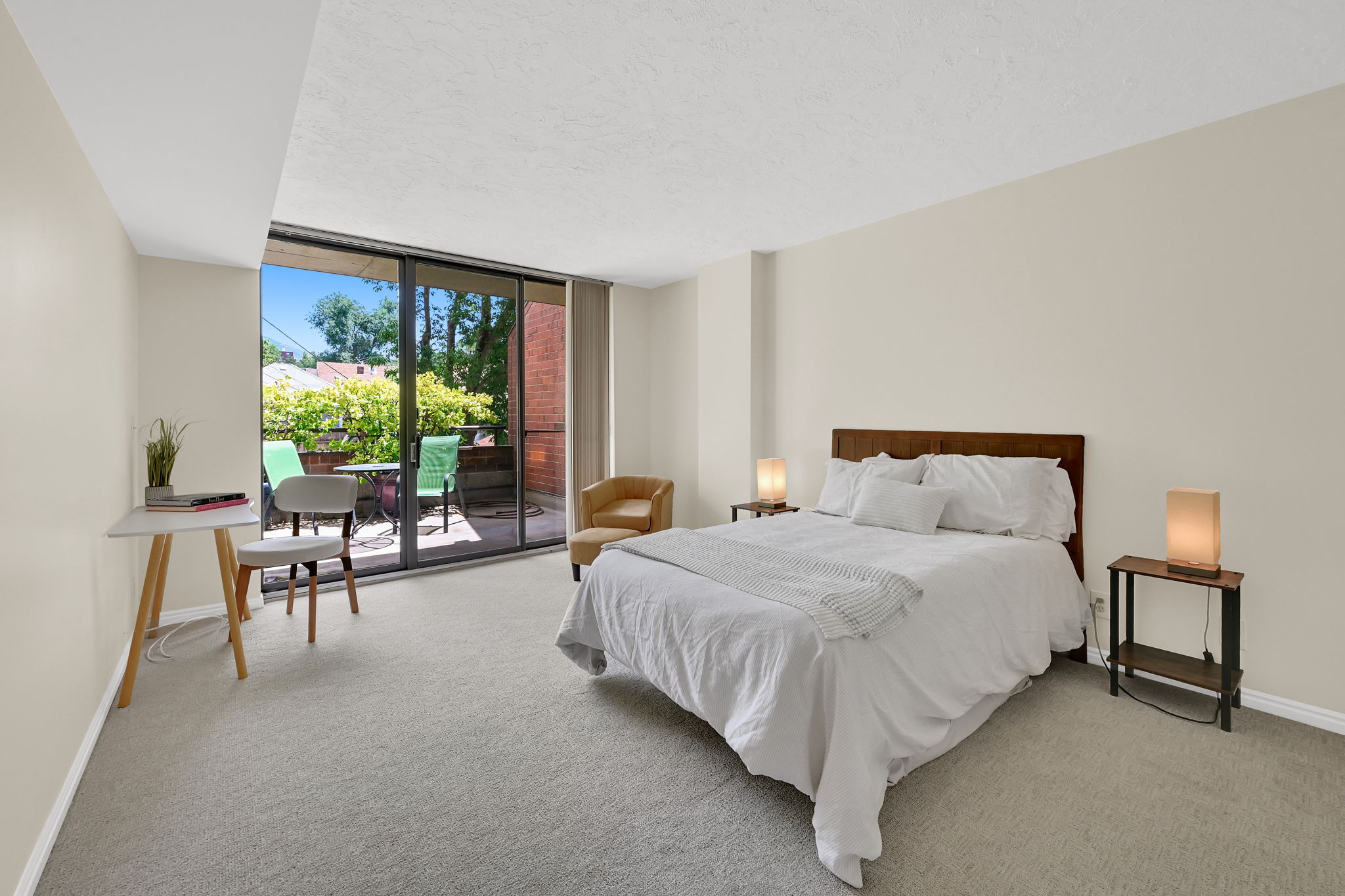 Sliding glass doors opening to a private outdoor patio, neutral wall paint, and light-colored carpeting