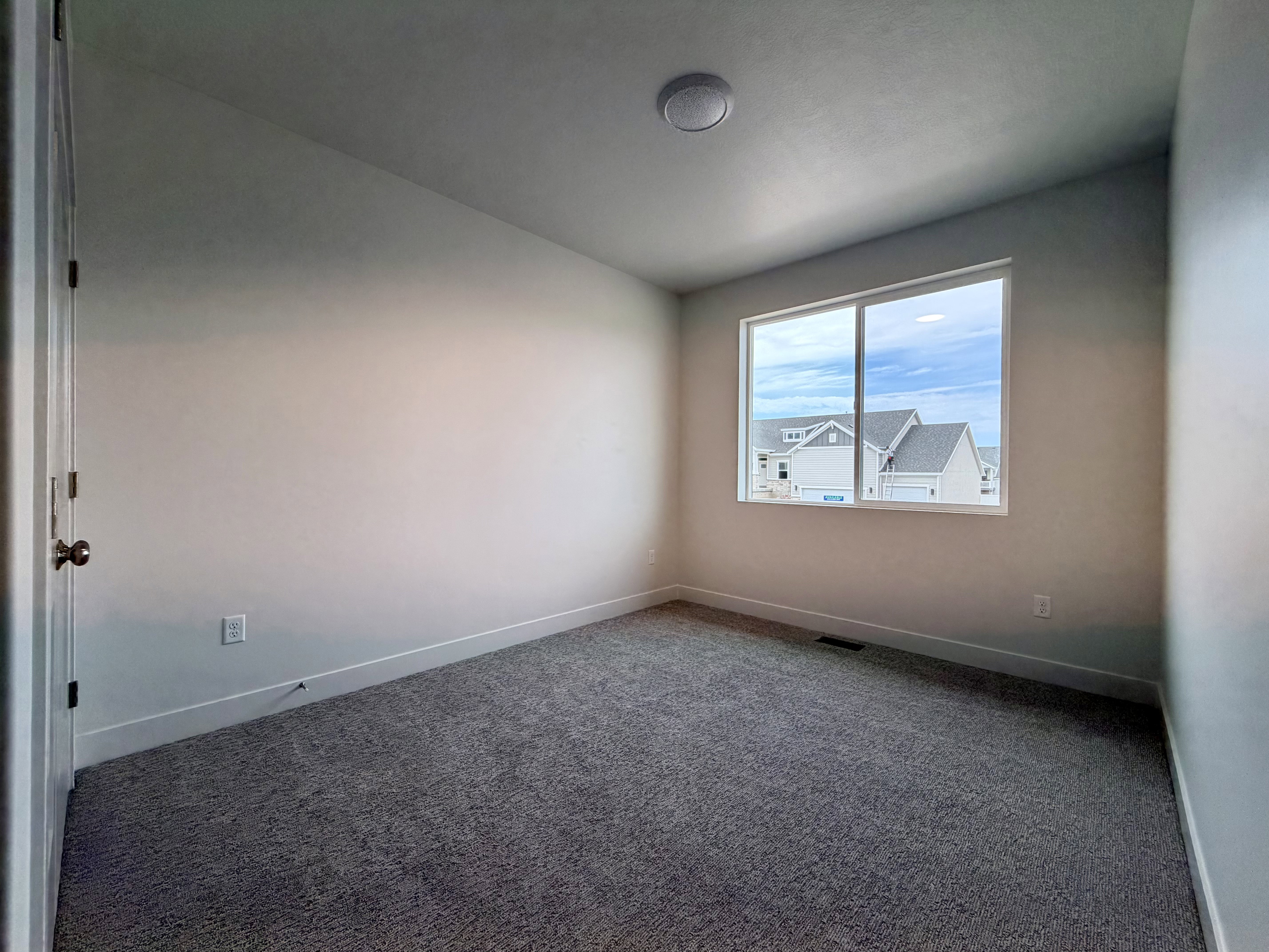 Room featuring gray carpeting, white baseboards, and a double-pane window with white trim