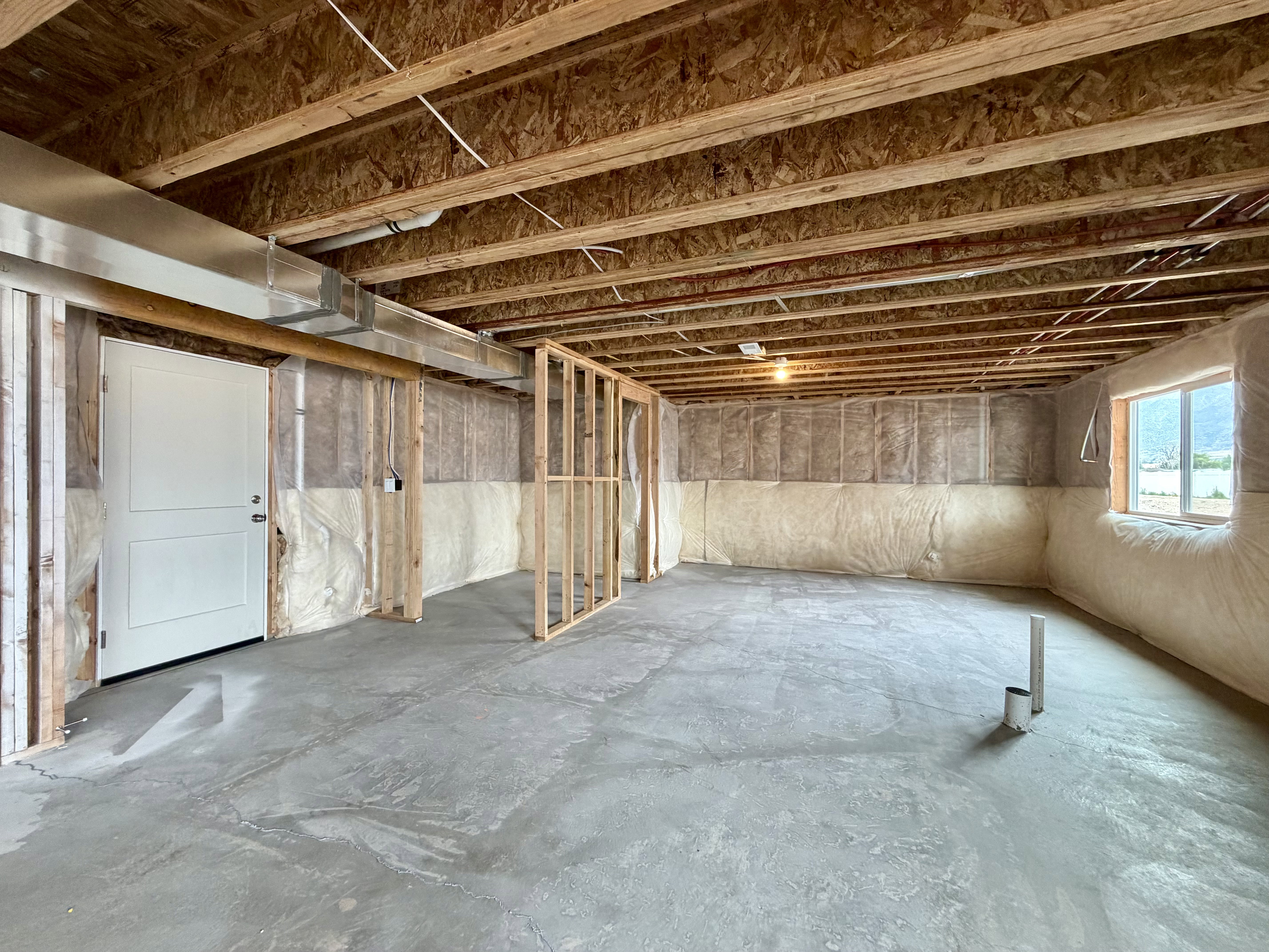 Unfinished basement presenting open floor space with concrete flooring