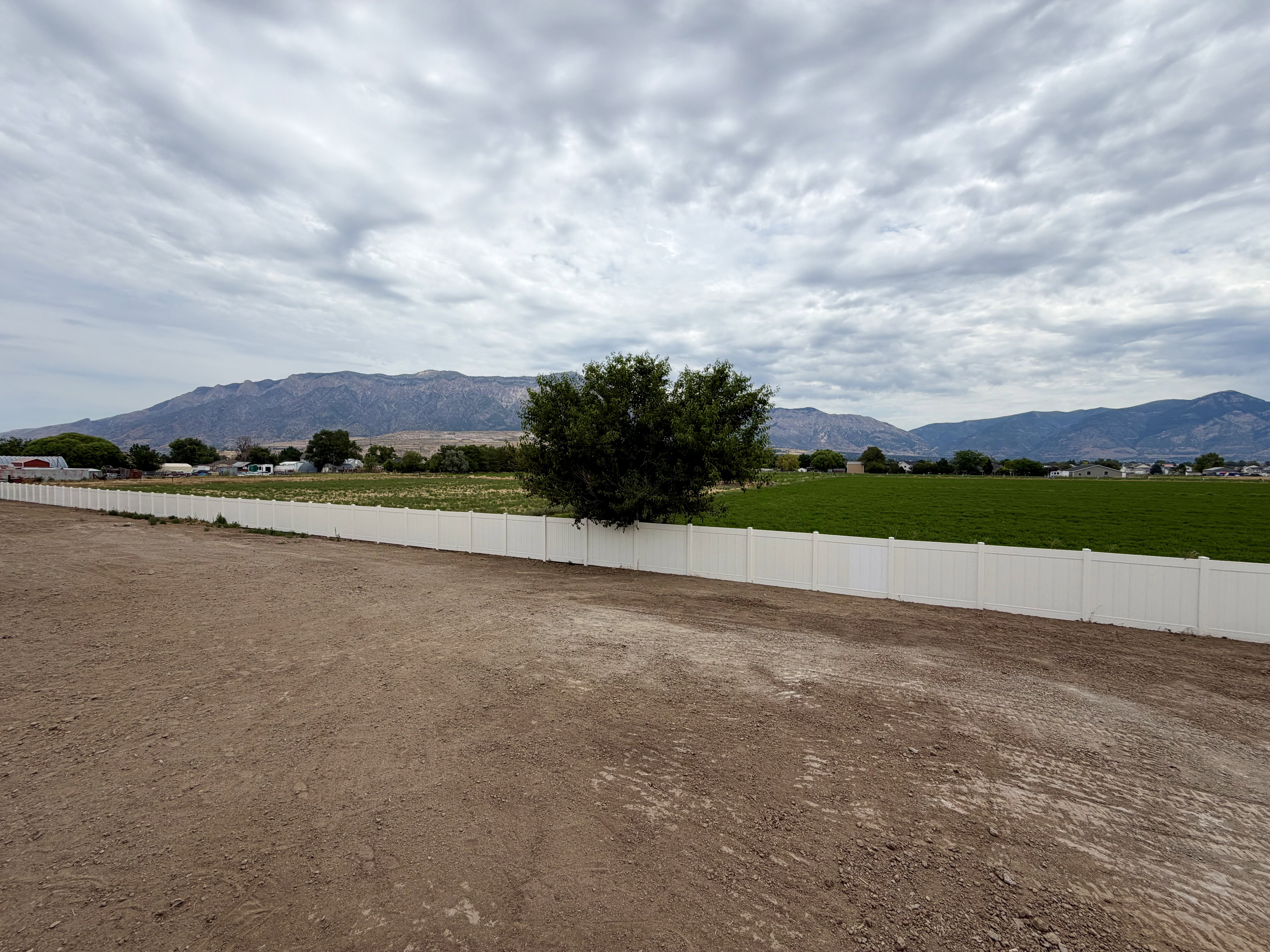 Expansive lot featuring a newly installed white privacy fence