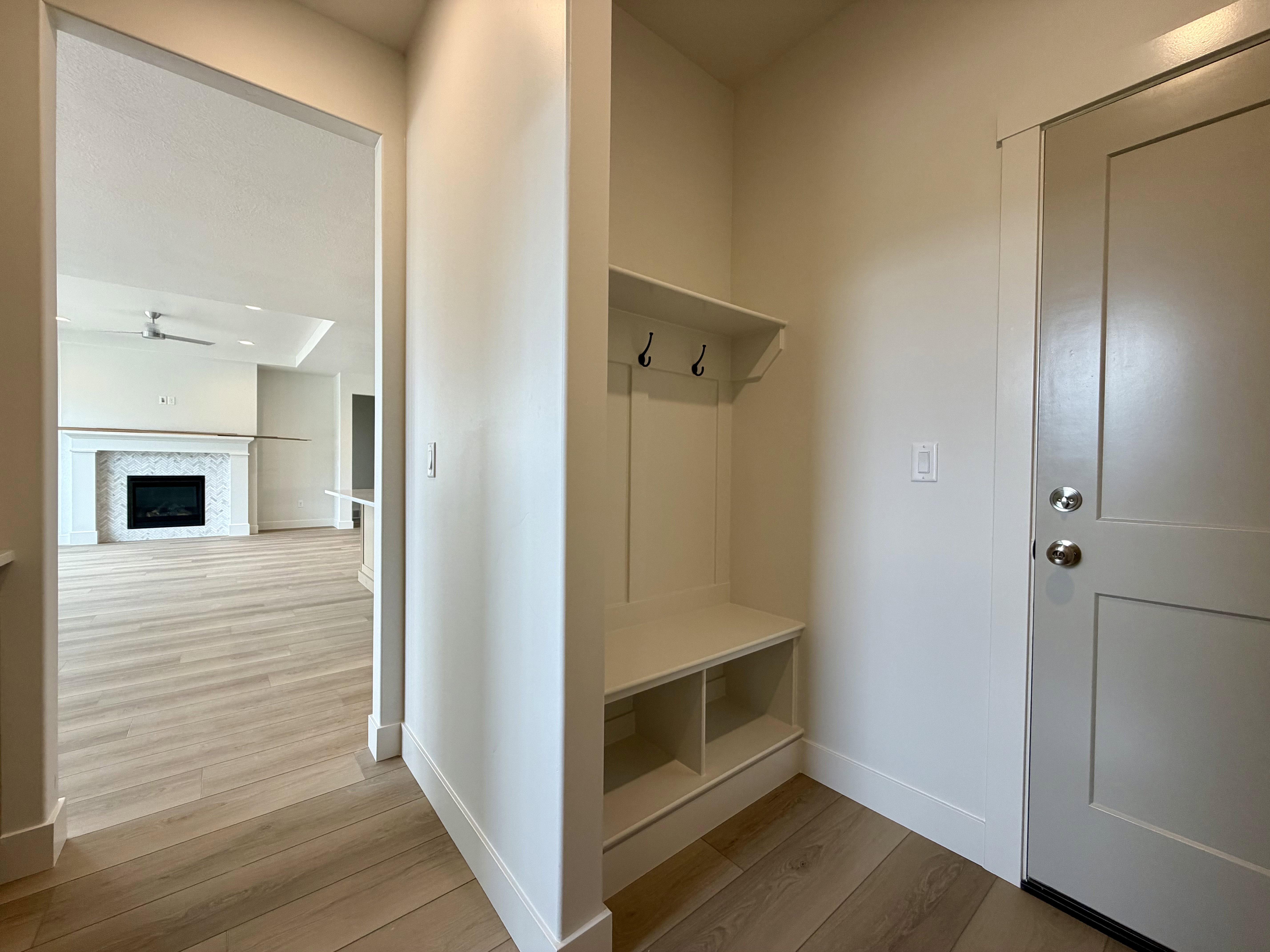 Entryway featuring built-in mudroom storage with bench seating and coat hooks