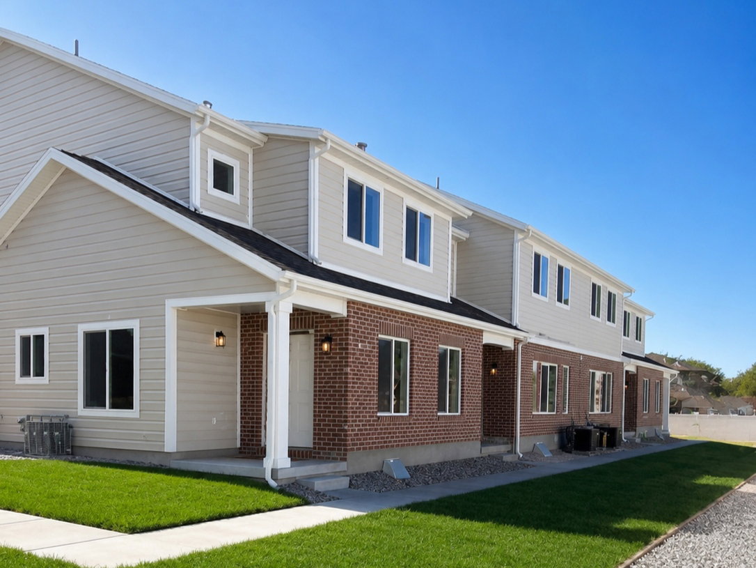 Contemporary townhome exterior featuring brick and light-toned siding