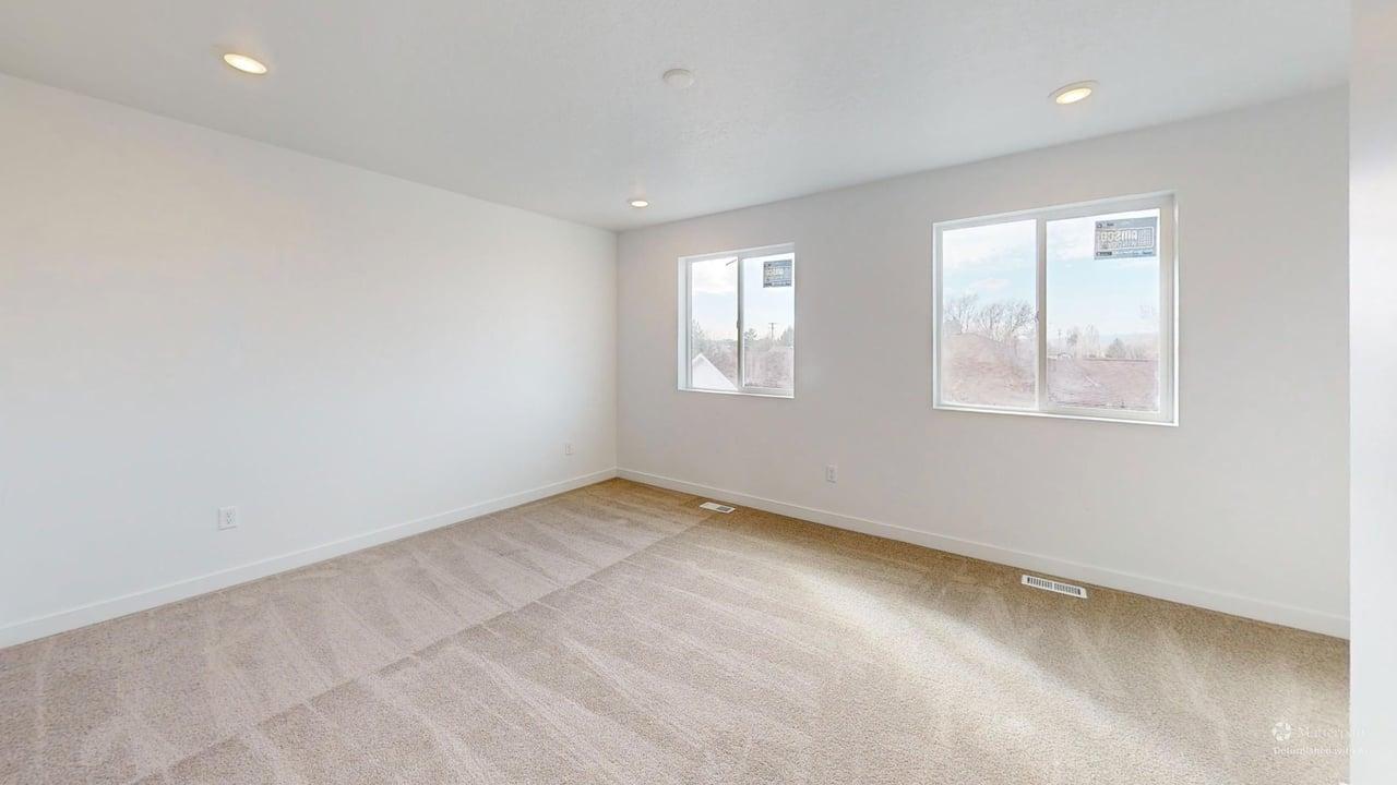 Expansive room featuring two large windows, recessed ceiling lighting, and neutral carpeting