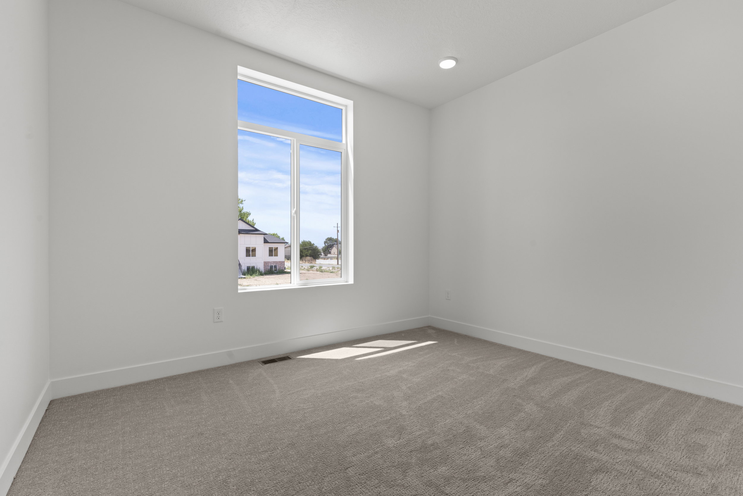 Neutral-toned wall-to-wall carpeting complements clean white walls