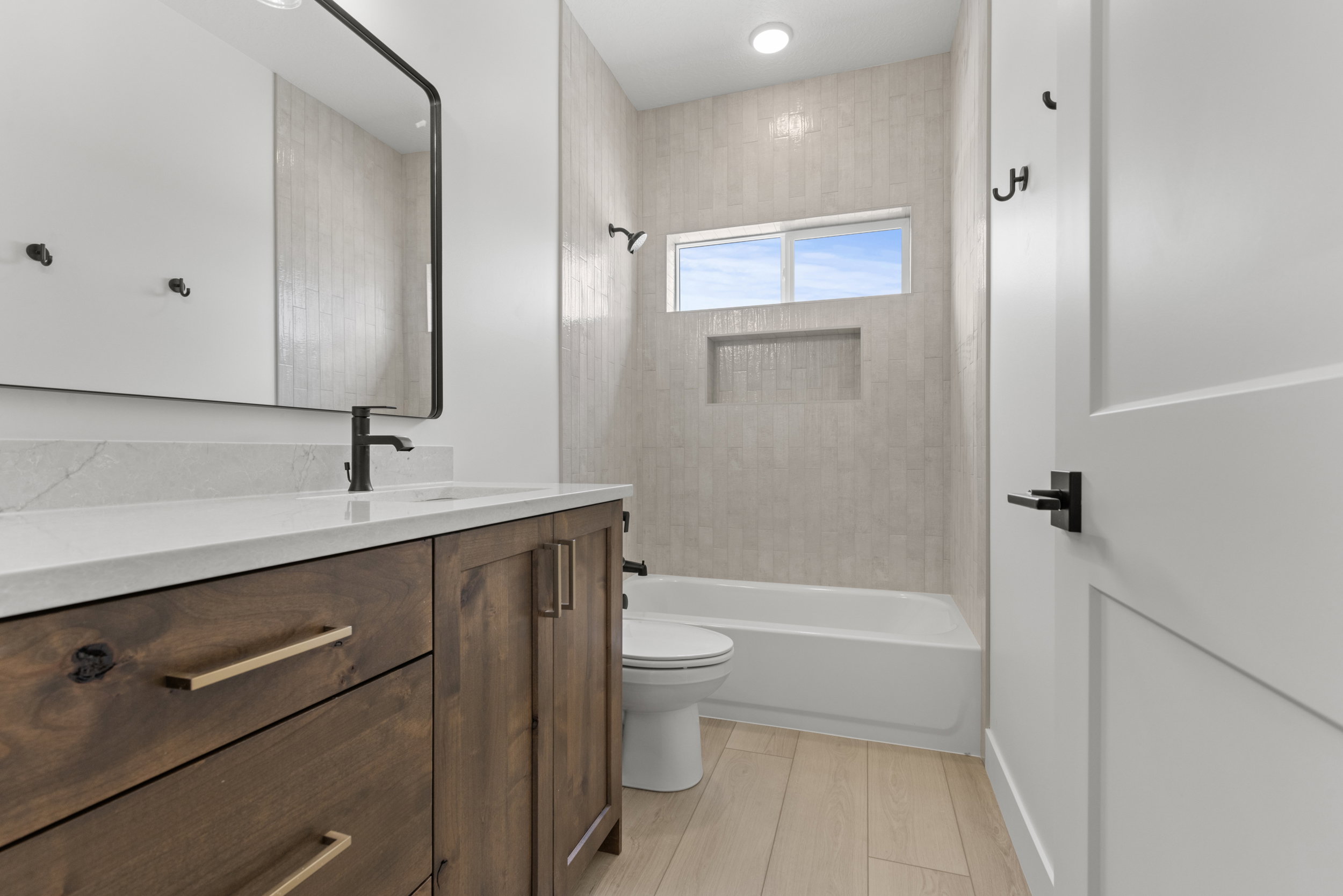 Modern bathroom featuring a wood-finish vanity with a white countertop and rectangular sink